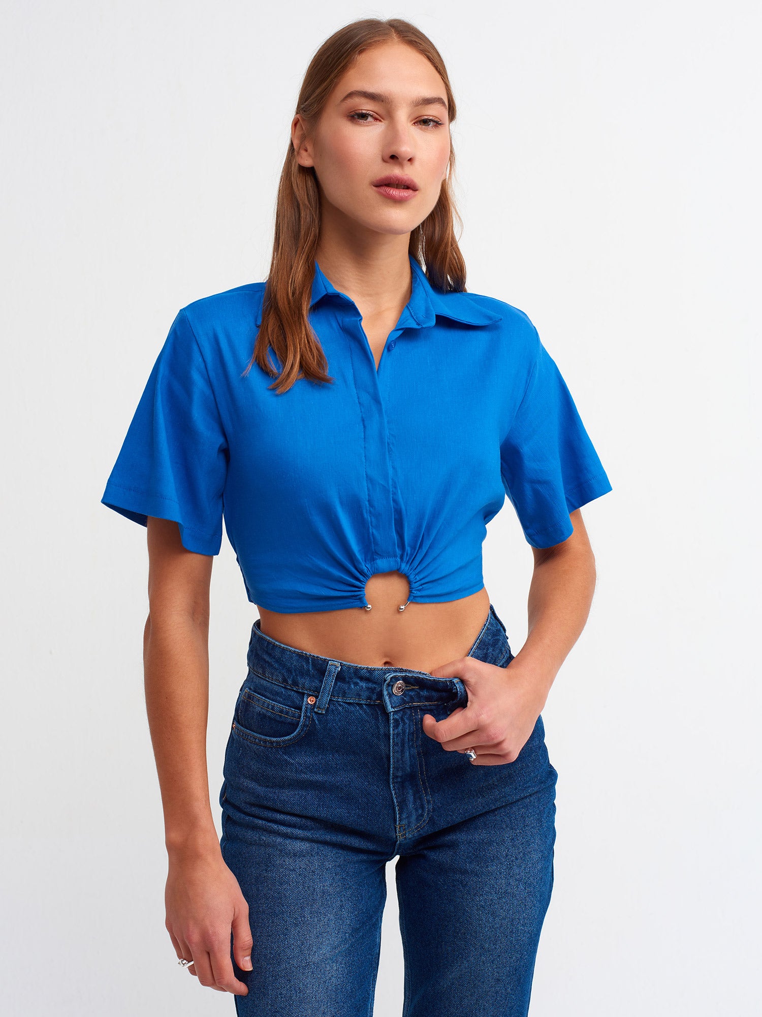 A stylish crop shirt made from a blend of linen, viscose, polyamide, and elastane, showcasing its trendy design and comfortable fit.