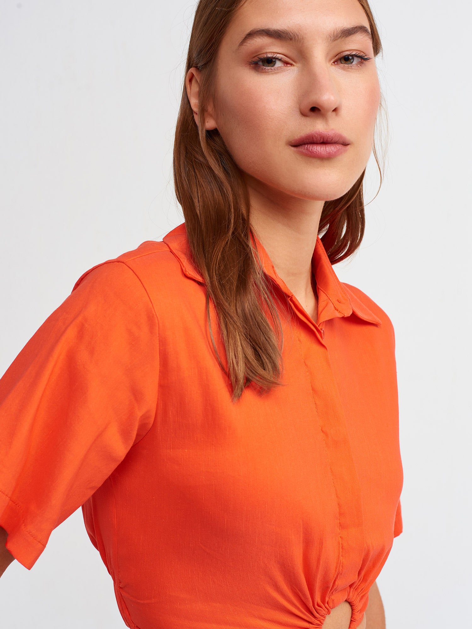 A stylish crop shirt made from a blend of linen, viscose, polyamide, and elastane, showcasing its trendy design and comfortable fit.