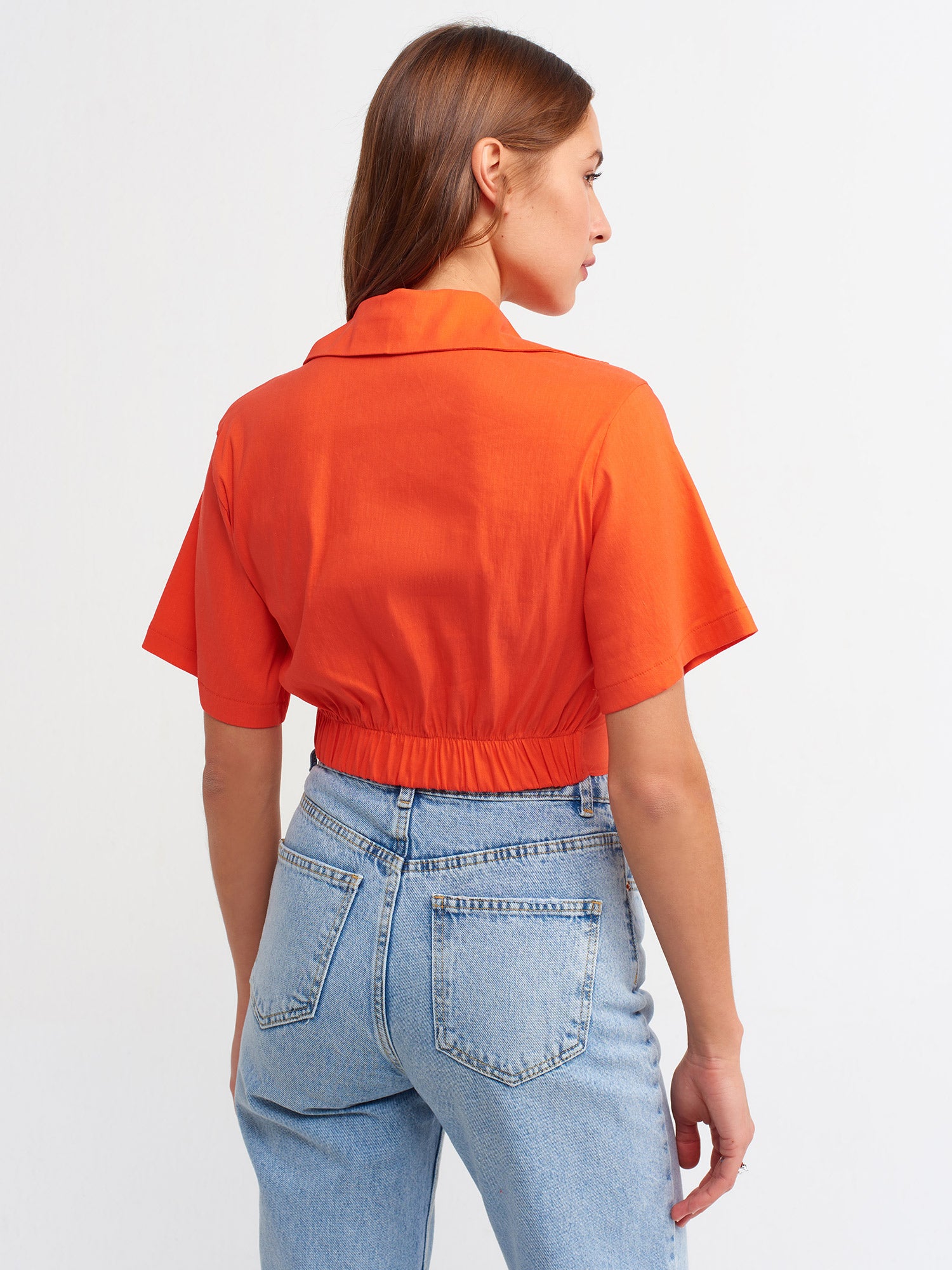 A stylish crop shirt made from a blend of linen, viscose, polyamide, and elastane, showcasing its trendy design and comfortable fit.