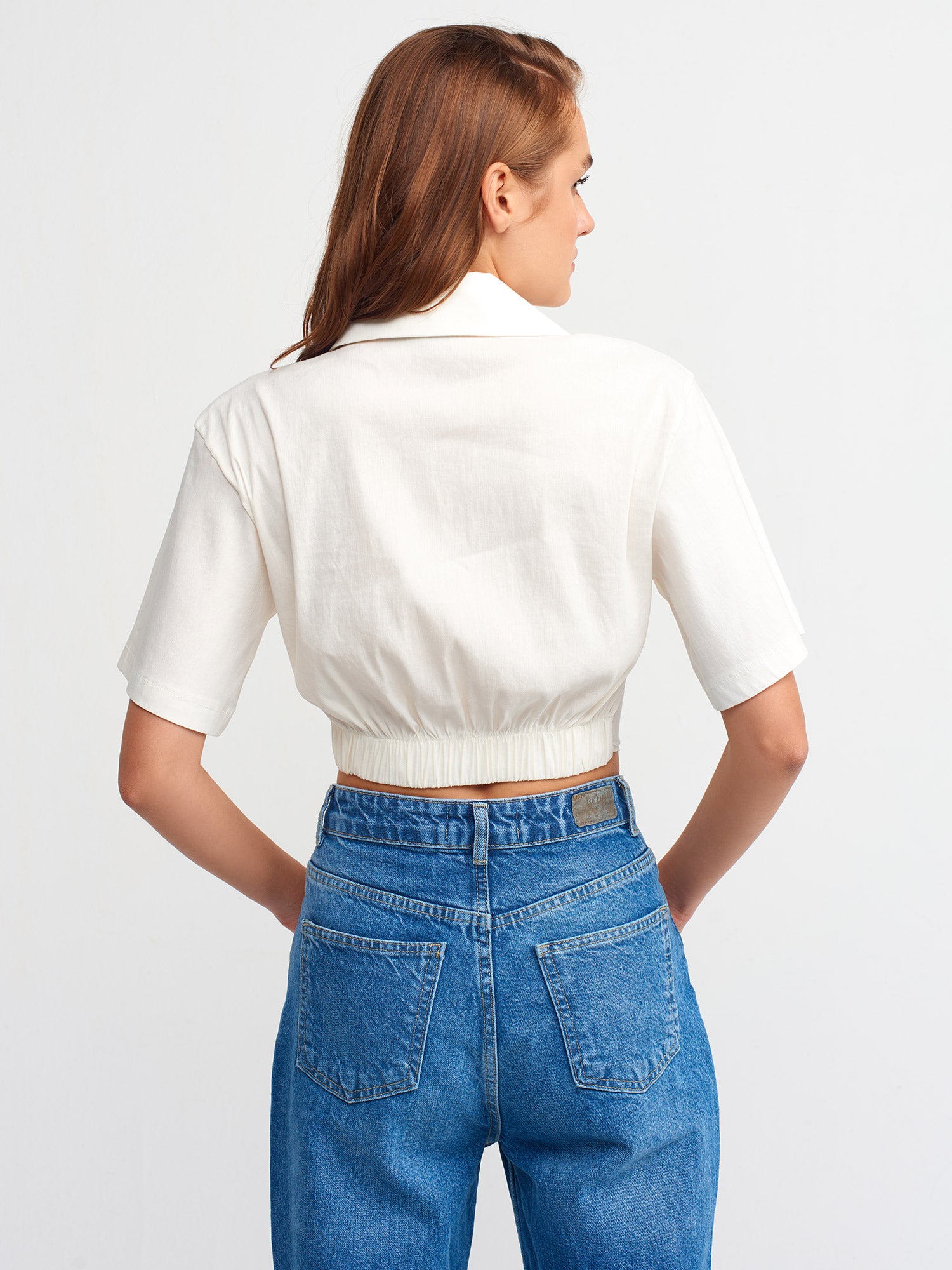 A stylish crop shirt made from a blend of linen, viscose, polyamide, and elastane, showcasing its trendy design and comfortable fit.