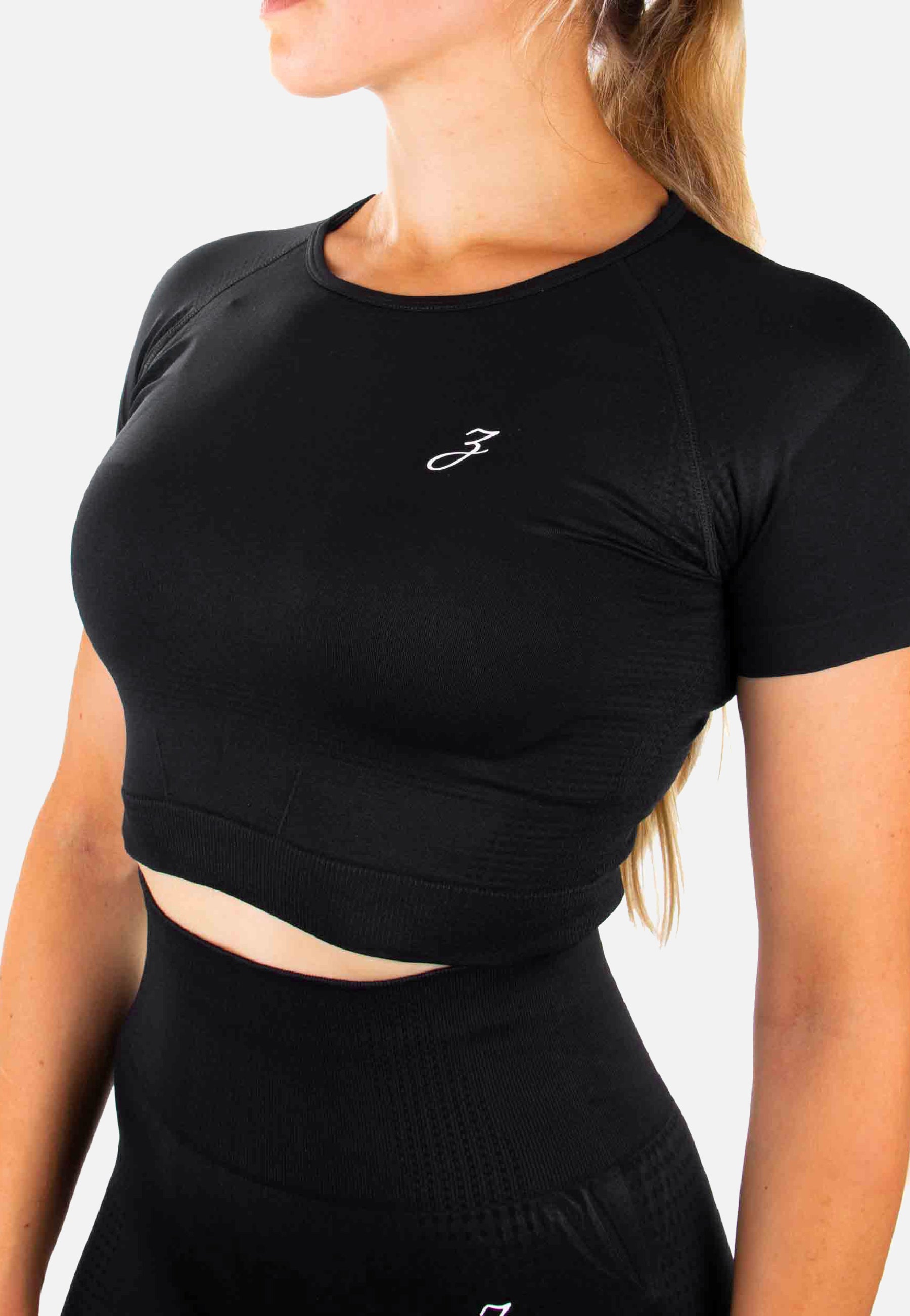 Schwarzes Crop Top Dynamic für Damen, figurbetont mit kurzen Ärmeln, ideal für Sport und Freizeit.