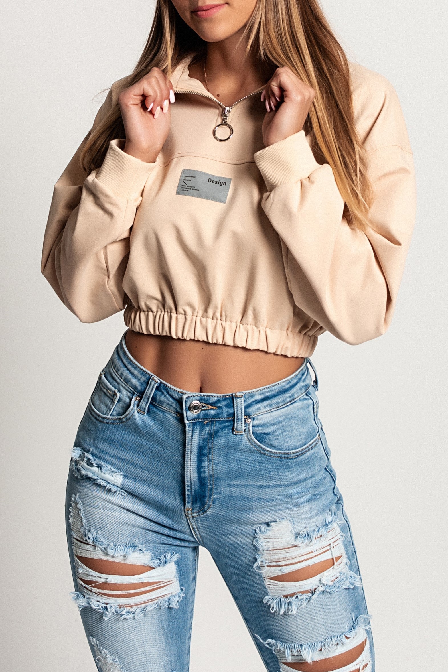 Cropped sports t-shirt Polistena in beige with long sleeves and high neck zipper, showcasing a stylish design.