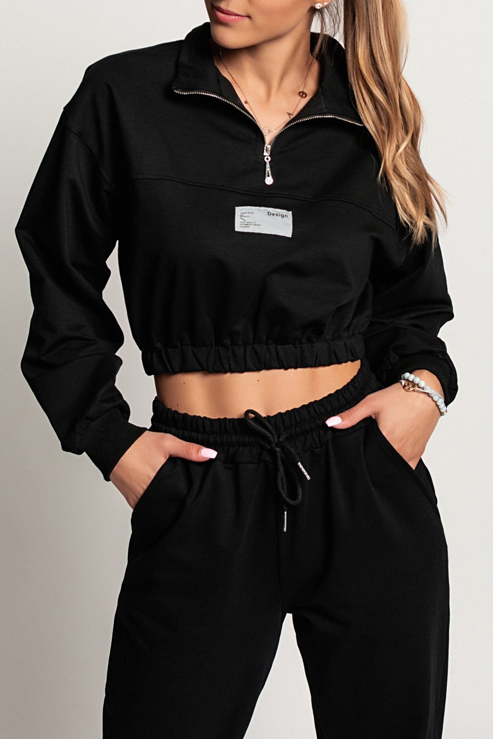 Cropped sports t-shirt Polistena in black with long sleeves and high neck zipper detail.