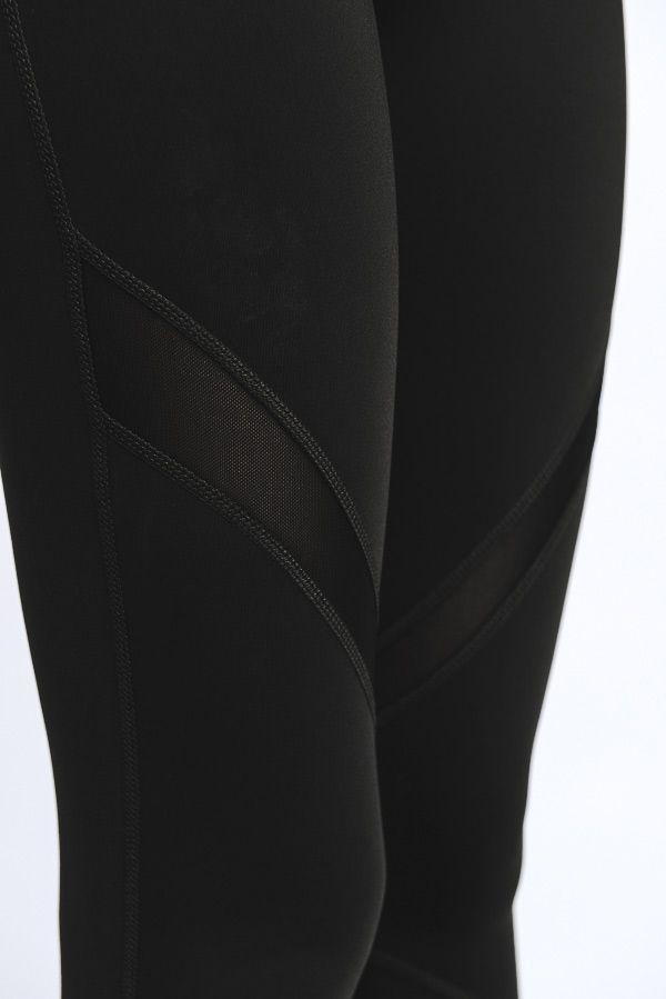 A pair of stylish black cross mesh leggings featuring slanted mesh panels and a zipper pocket on the back.