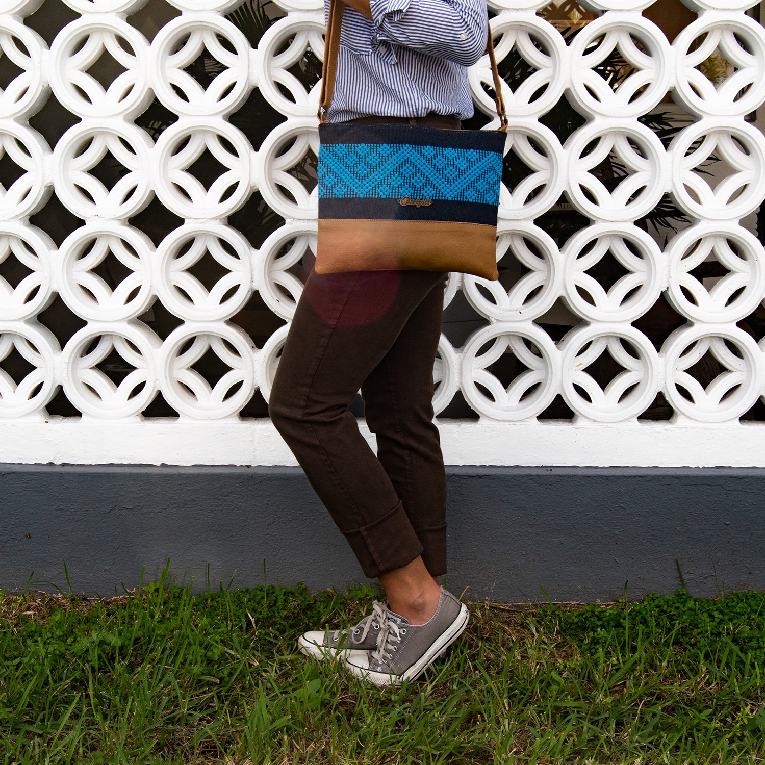 Stylish camel leather cross-body bag with blue stripe, featuring a zipper closure and adjustable strap.