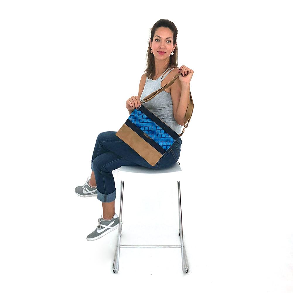 Stylish camel leather cross-body bag with blue stripe, featuring a zipper closure and adjustable strap.