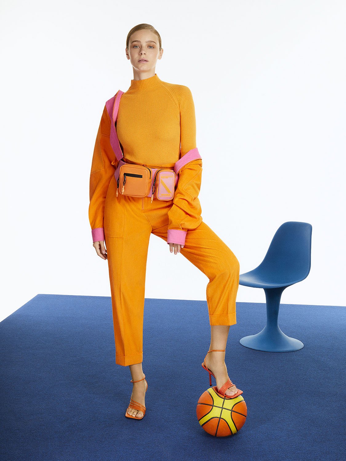 A pair of stylish cuffed corduroy pants in vibrant orange, pink, and blue colors, featuring a high-waisted design and elastic waistband.