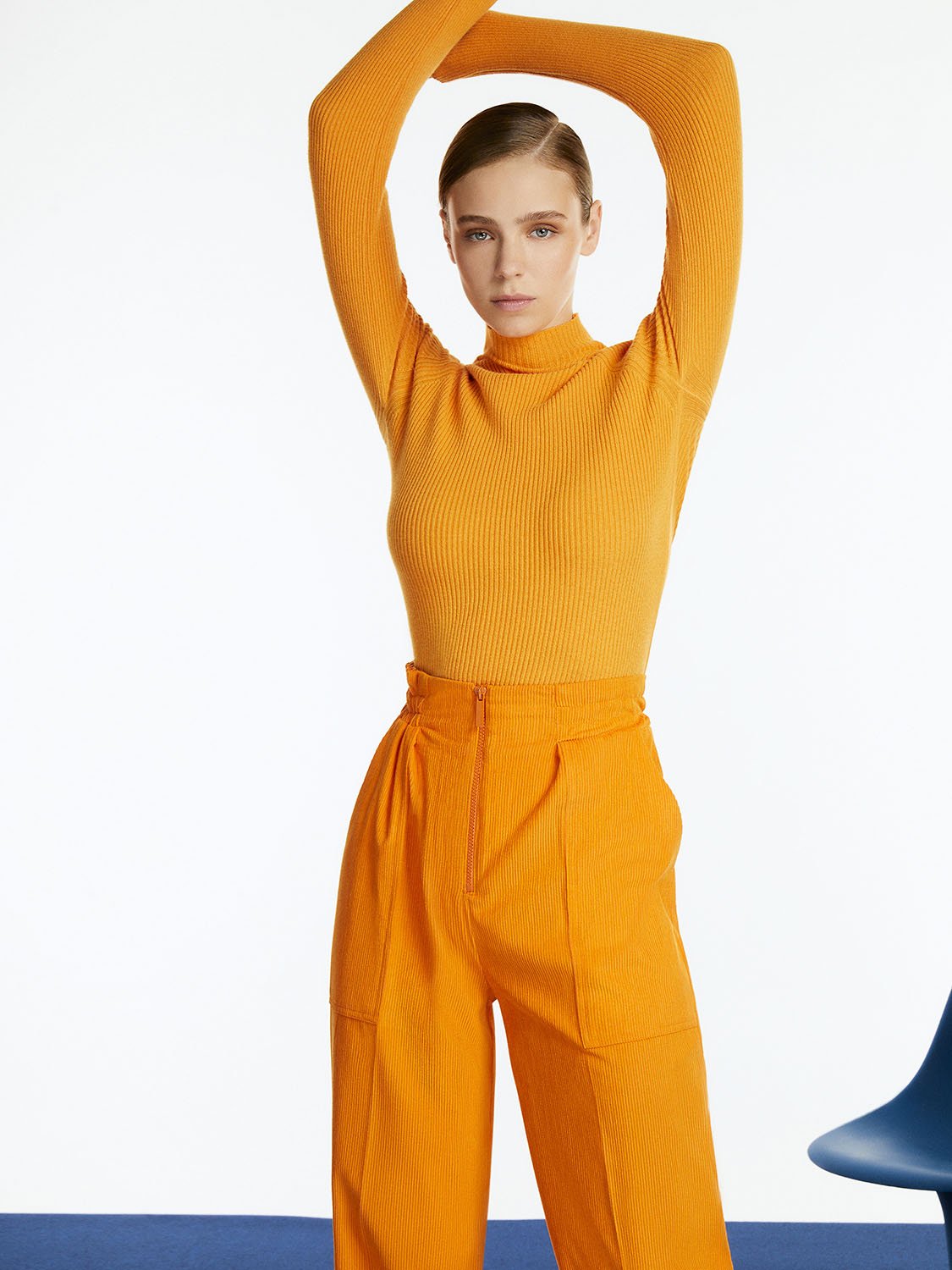 A pair of stylish cuffed corduroy pants in vibrant orange, pink, and blue colors, featuring a high-waisted design and elastic waistband.