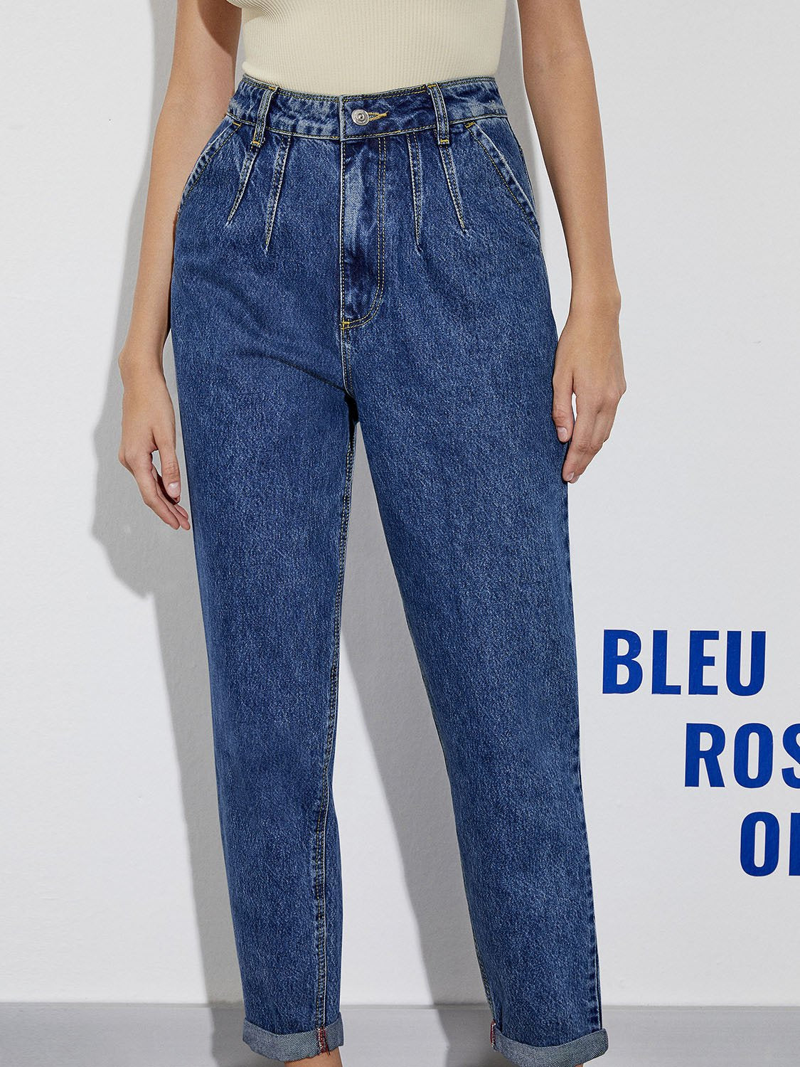 A pair of stylish cuffed hem mom jeans featuring a high-waisted design, front button and zip closure, and practical side and back pockets.