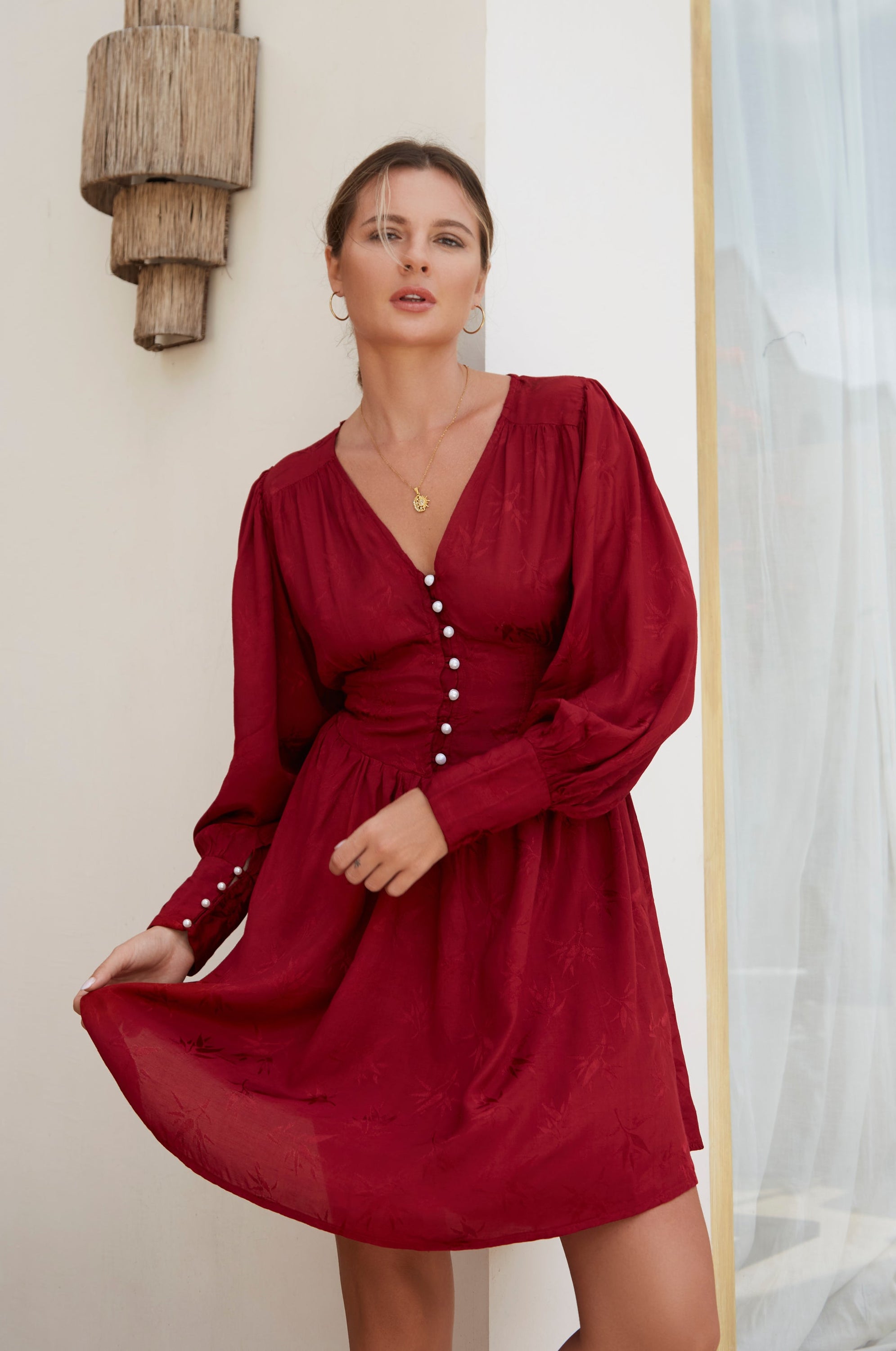 Daphne Floaty Long Sleeve Mini Dress featuring a romantic silhouette, voluminous sleeves, and pearl button details, made from soft organic cotton.