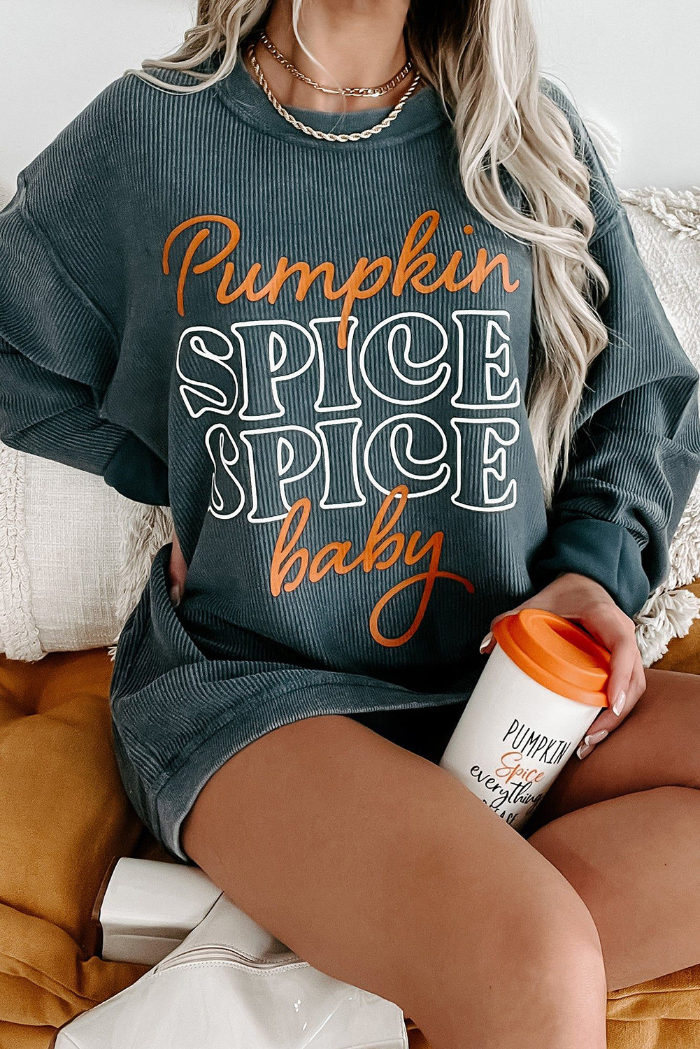 Dark grey textured sweatshirt featuring a playful pumpkin spice baby graphic, perfect for Halloween.