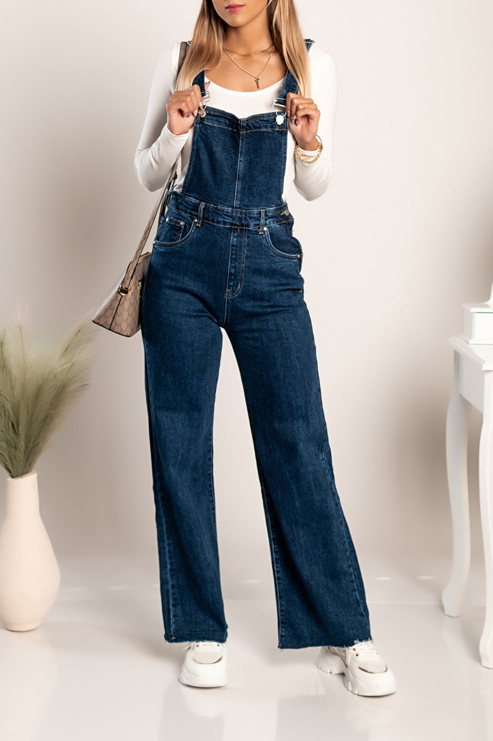 Dark blue denim jumpsuit Chiessa with adjustable straps and frayed hem, featuring side button and zipper closure.