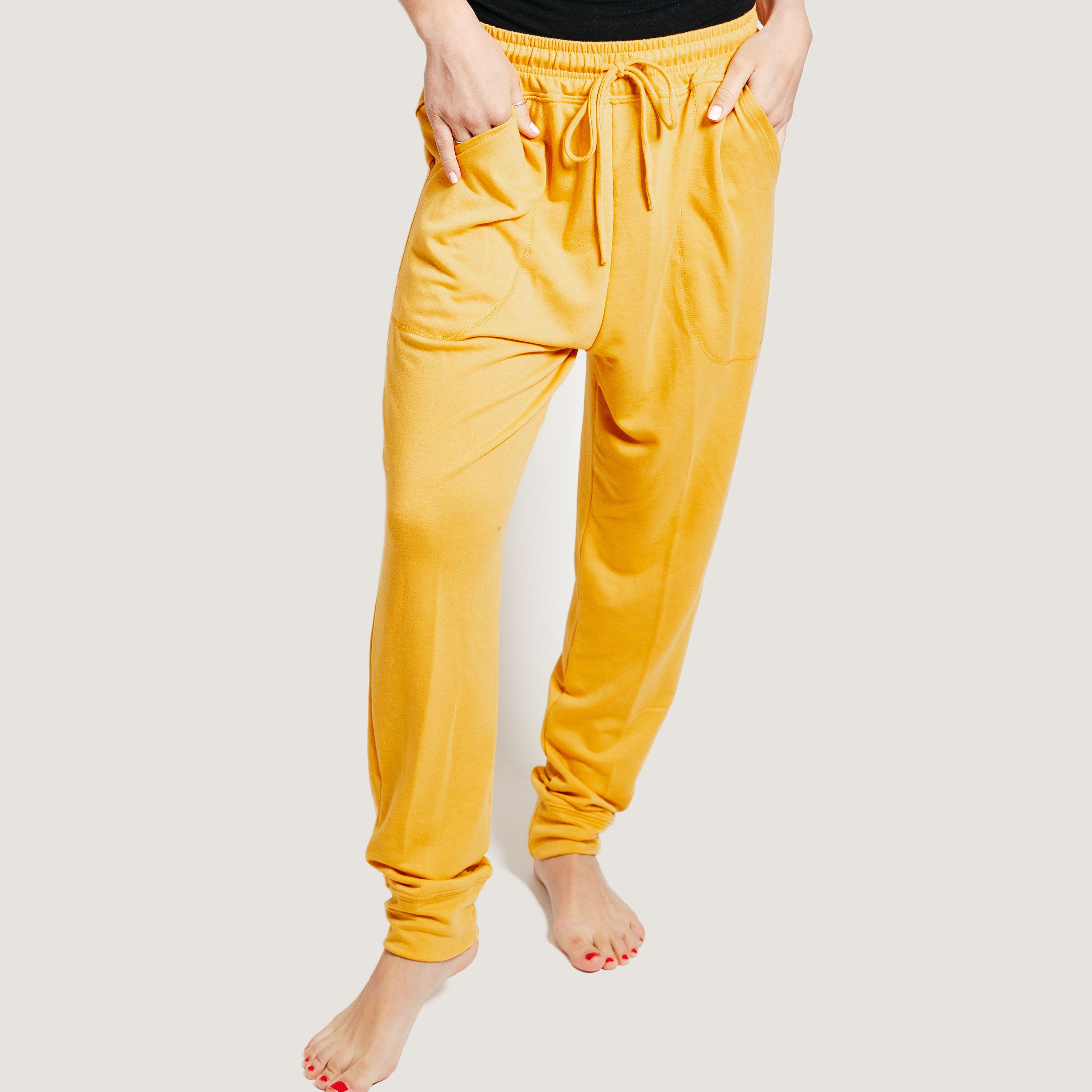 A pair of mustard yellow deep pocket joggers with a drawstring waistband, showcasing their soft fabric and stylish design.