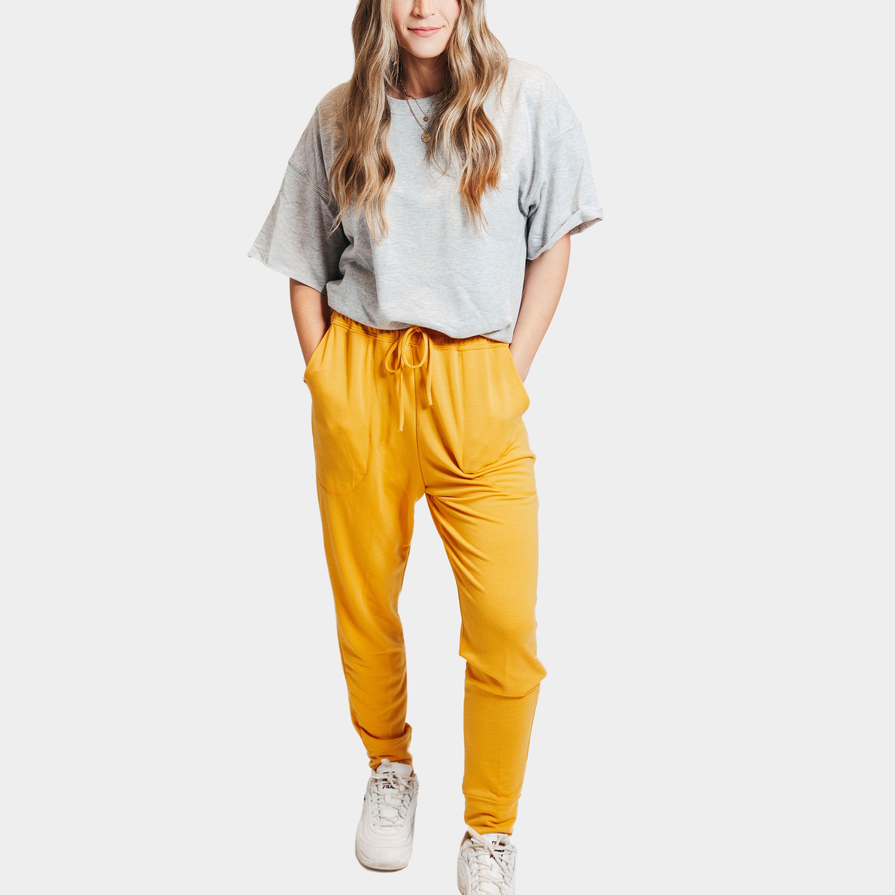 A pair of mustard yellow deep pocket joggers with a drawstring waistband, showcasing their soft fabric and stylish design.