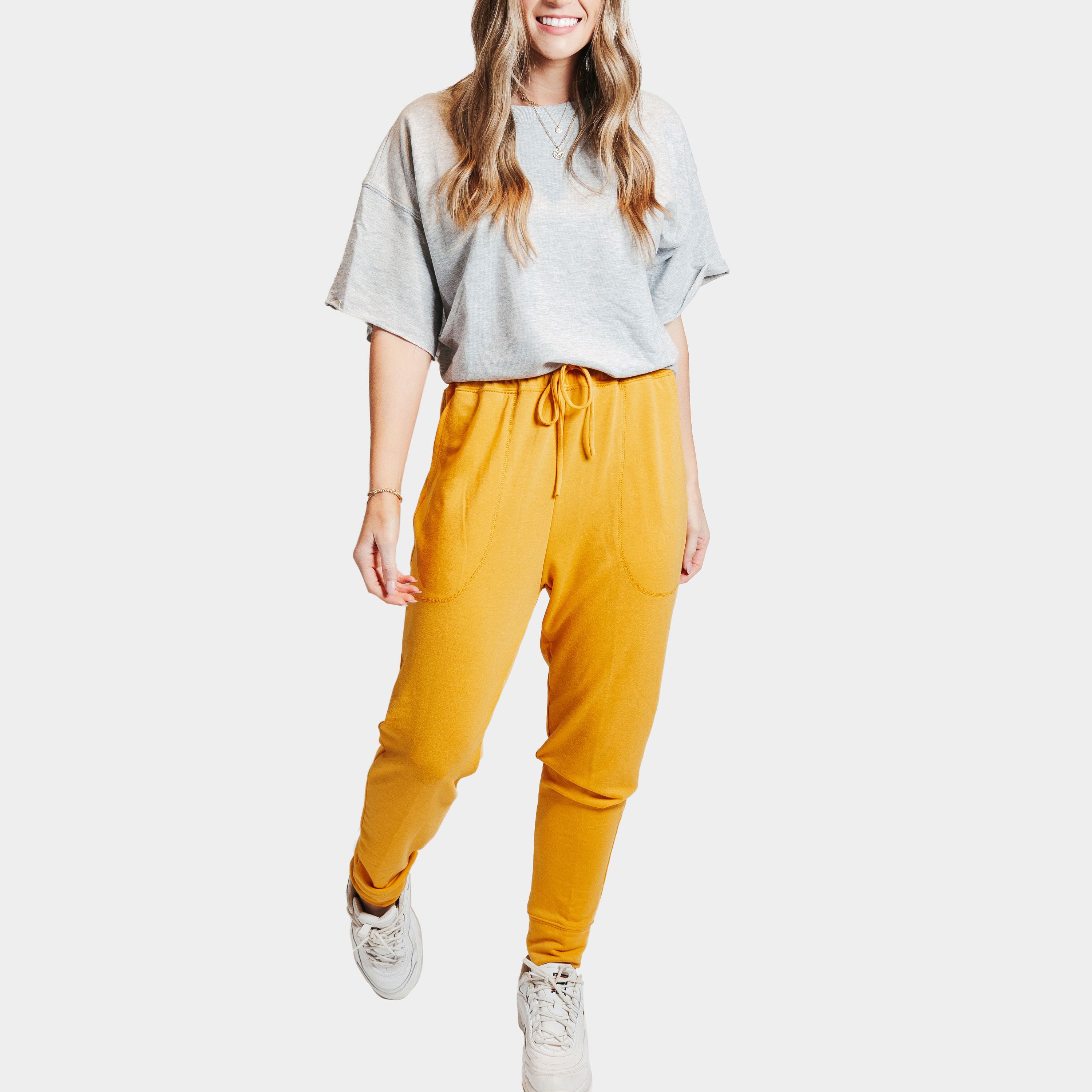 A pair of mustard yellow deep pocket joggers with a drawstring waistband, showcasing their soft fabric and stylish design.