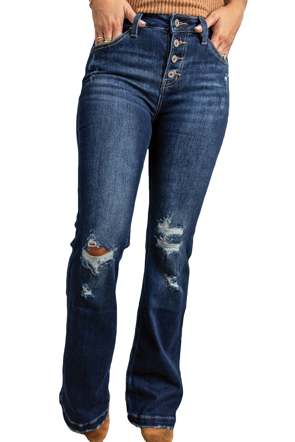 A pair of distressed flare bottom jeans featuring a medium wash, frayed hem, and 4-button closure, styled on a mannequin.