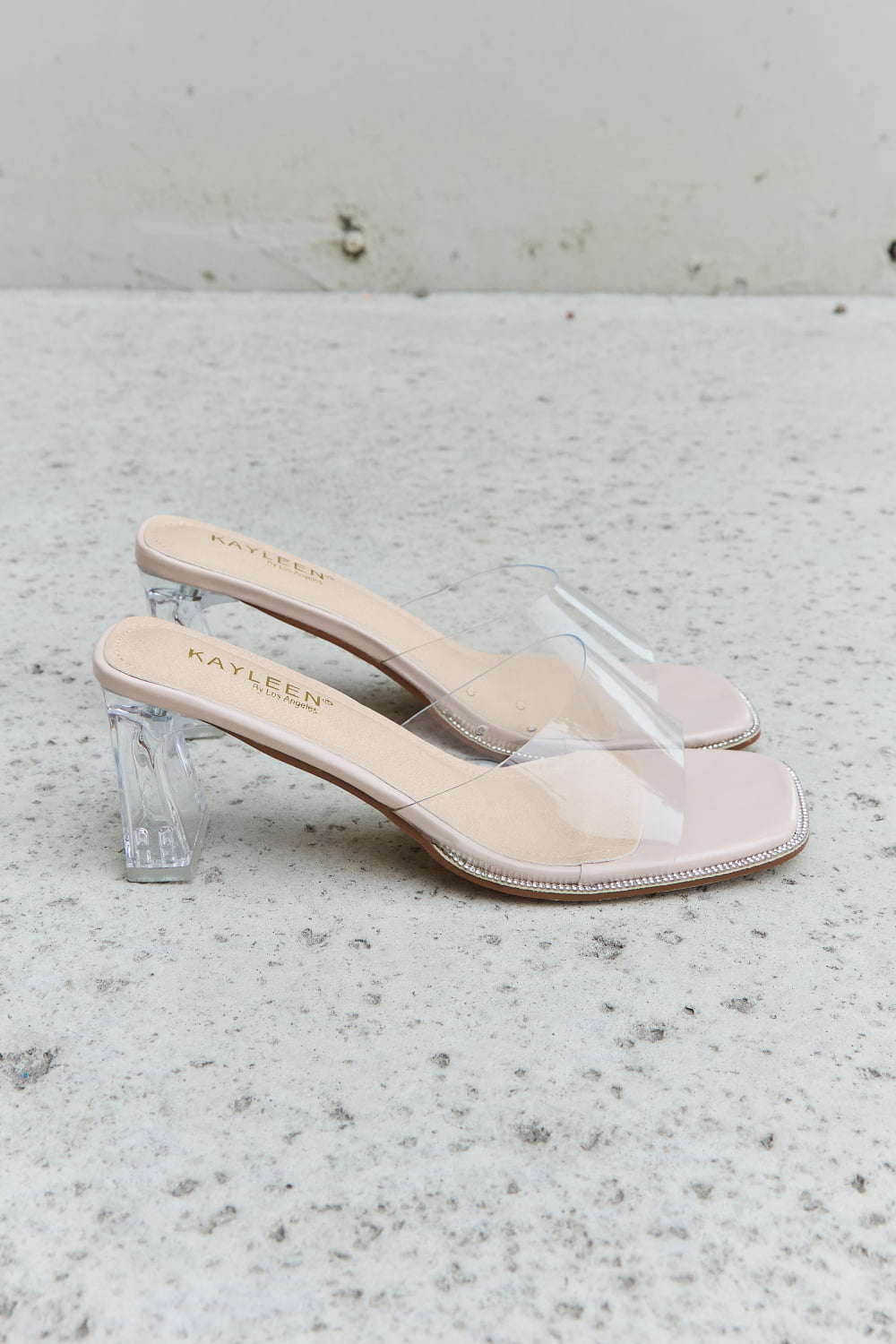 DDK Make Myself Clear Mule Block Heels featuring a transparent strap and block heel in a nude color.