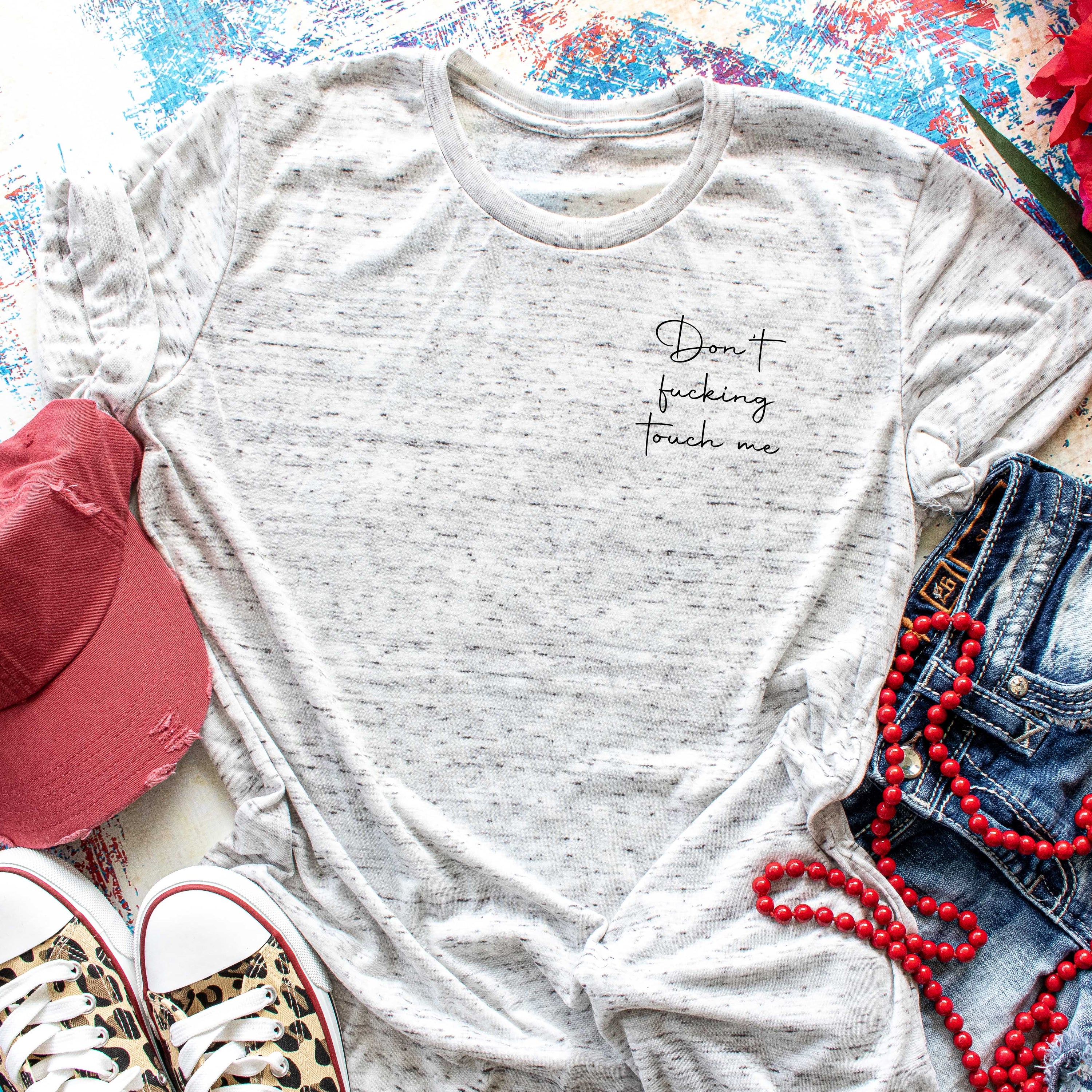 White heathered adult tee featuring a bold black design that reads 'Dont Fu*king Touch Me', showcasing its casual and edgy style.