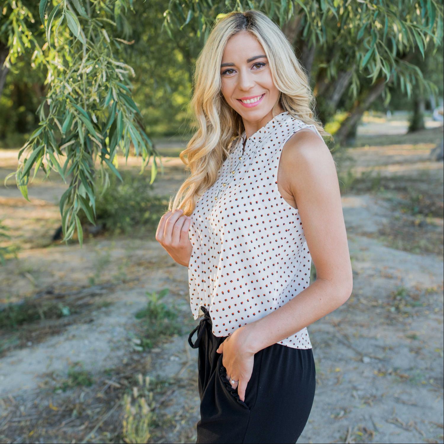 A stylish dot print sleeveless top in silk, featuring a partial button-down design, perfect for summer workwear.