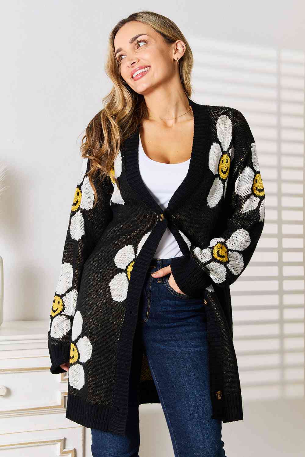 A stylish longline cardigan featuring a vibrant floral pattern, button-down front, and ribbed details, perfect for layering in any season.