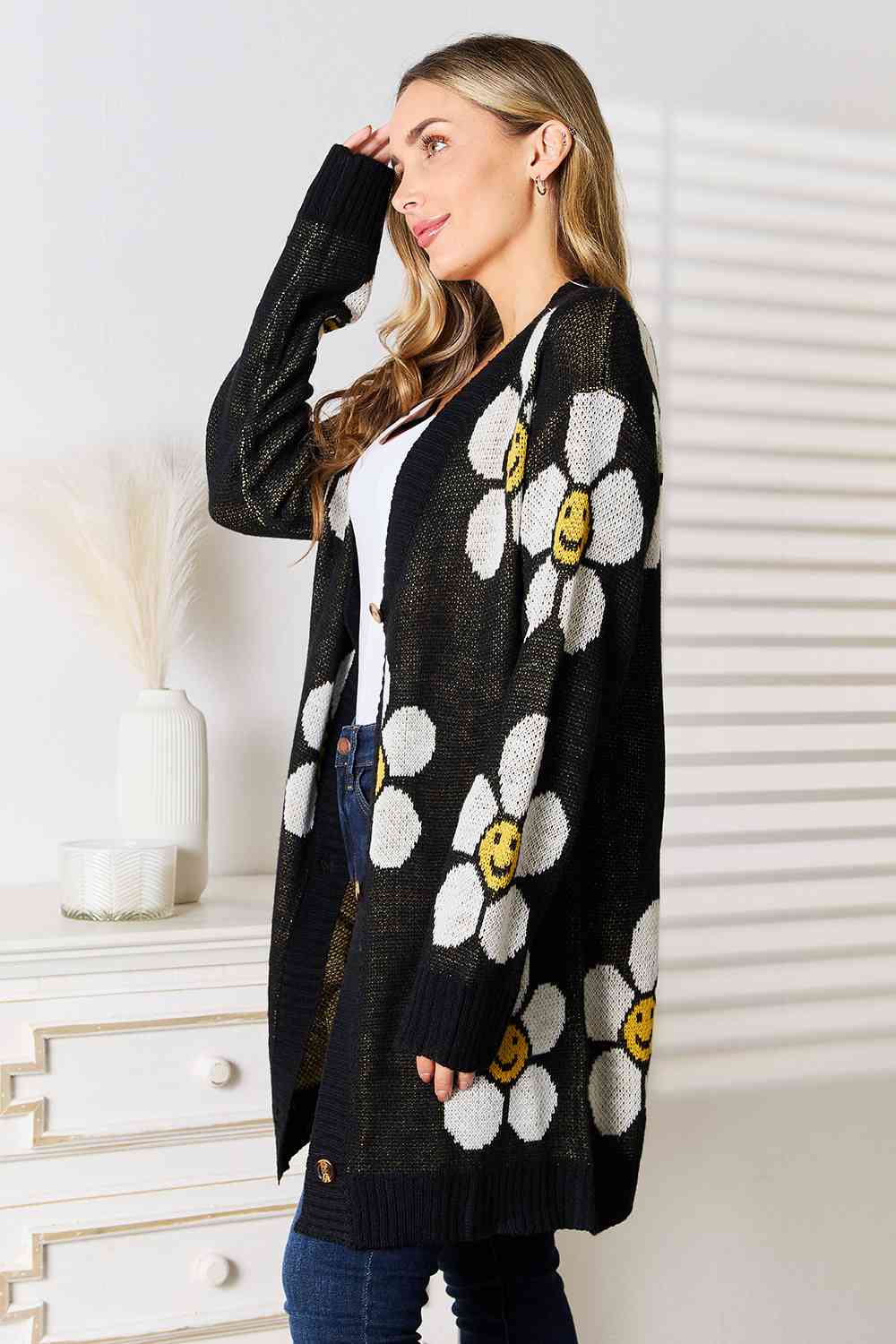 A stylish longline cardigan featuring a vibrant floral pattern, button-down front, and ribbed details, perfect for layering in any season.