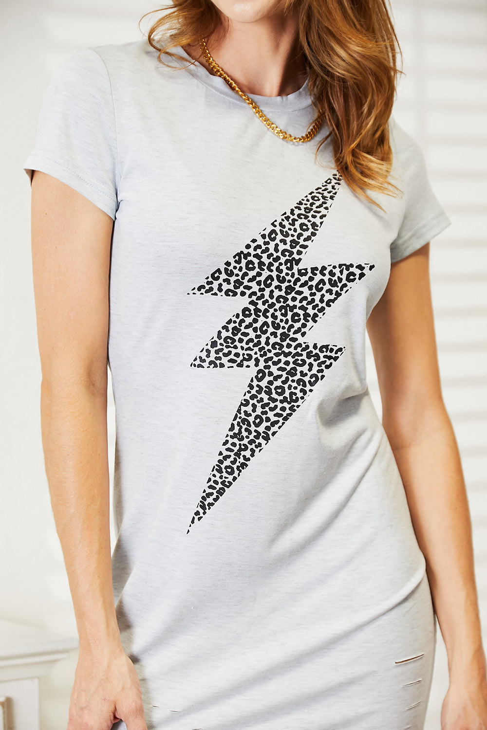 Double Take Leopard Lightning Graphic Tee Dress featuring a round neck and short sleeves with a leopard lightning graphic.