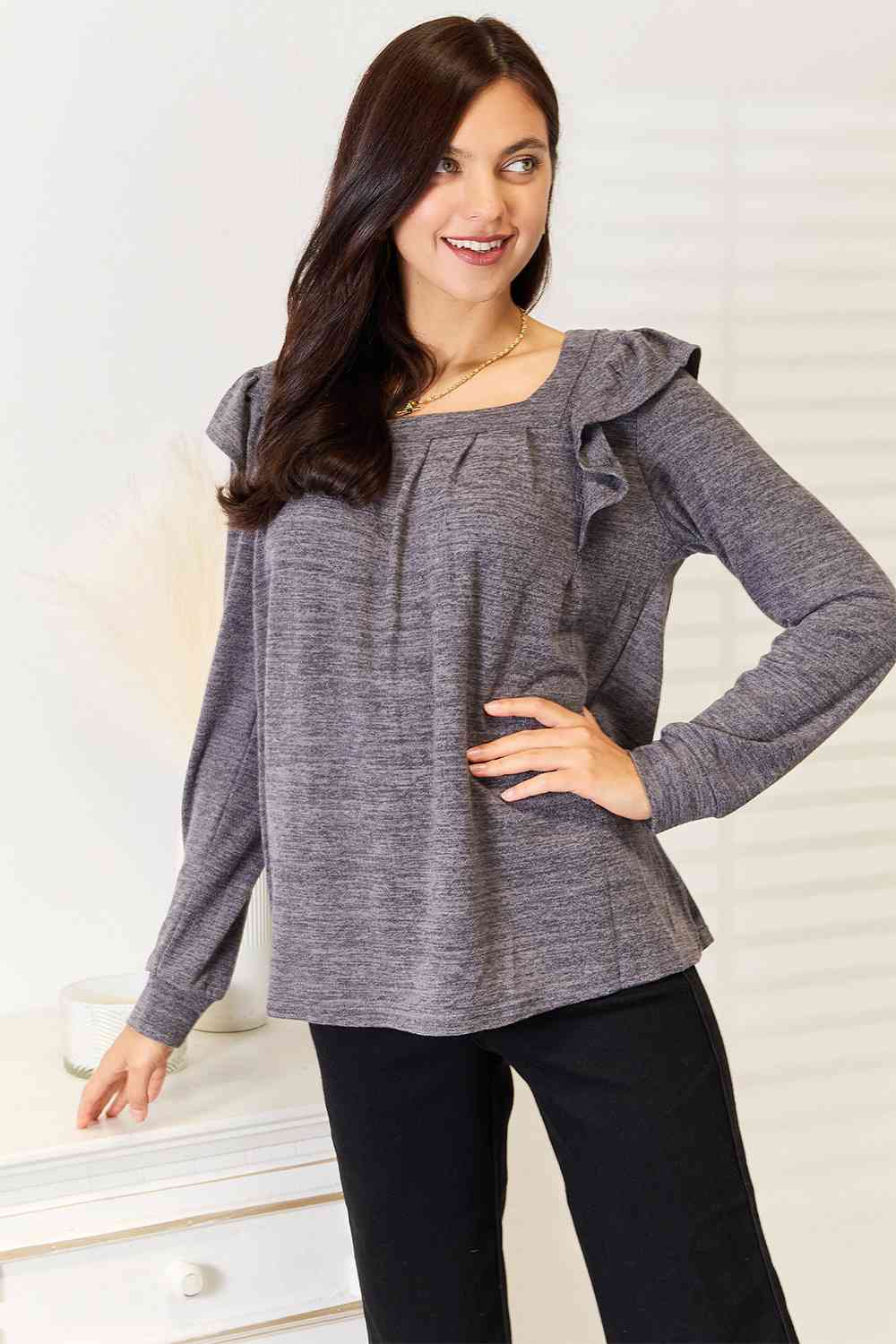 A stylish woman wearing a Double Take Square Neck Ruffle Shoulder Long Sleeve T-Shirt, showcasing its elegant square neckline and ruffle shoulder details.