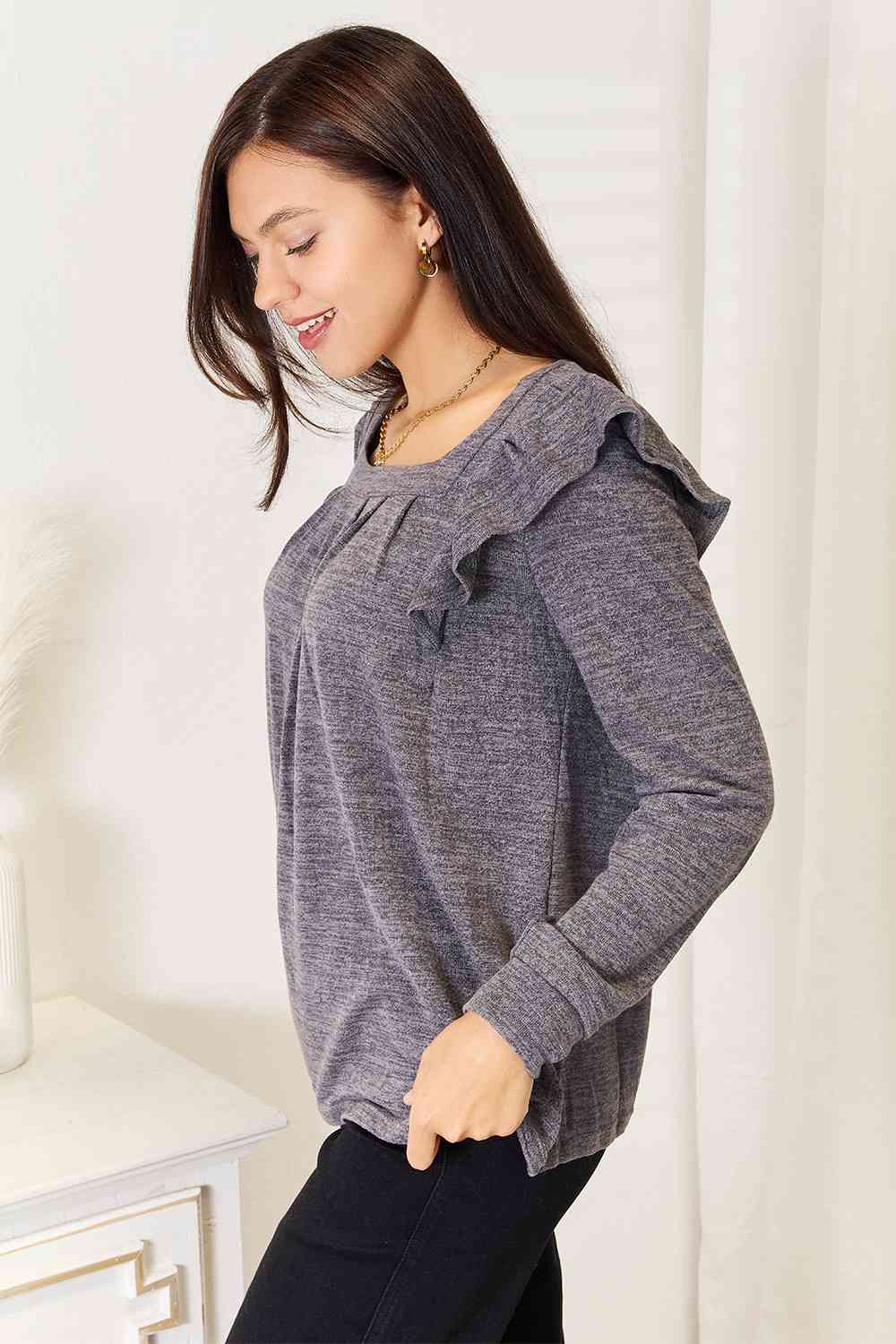 A stylish woman wearing a Double Take Square Neck Ruffle Shoulder Long Sleeve T-Shirt, showcasing its elegant square neckline and ruffle shoulder details.