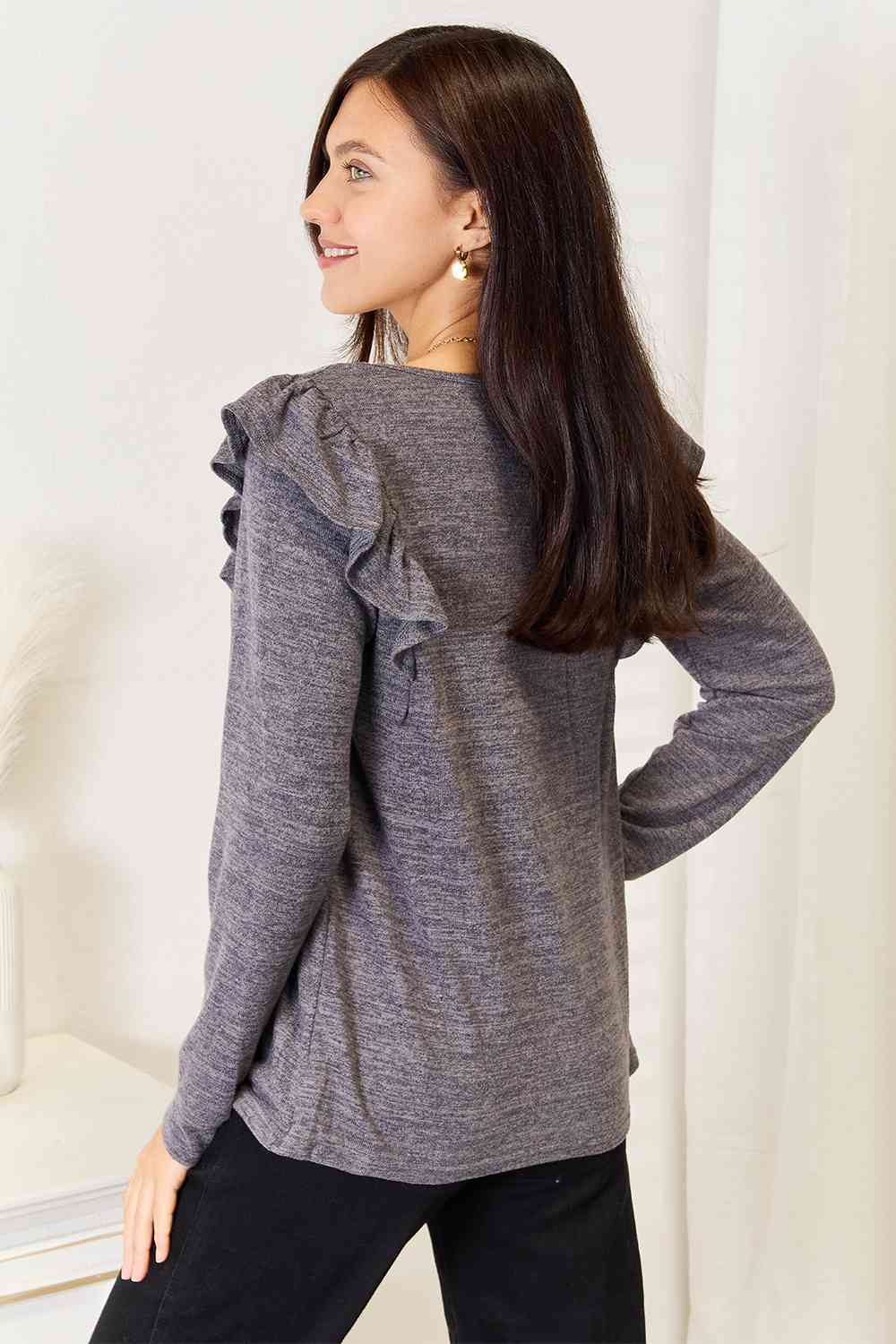 A stylish woman wearing a Double Take Square Neck Ruffle Shoulder Long Sleeve T-Shirt, showcasing its elegant square neckline and ruffle shoulder details.