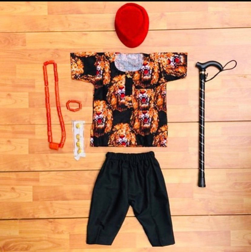 Dozie African set for boys featuring a shirt, pants, red hat, jewelry, and a walking stick, showcasing traditional Igbo attire.