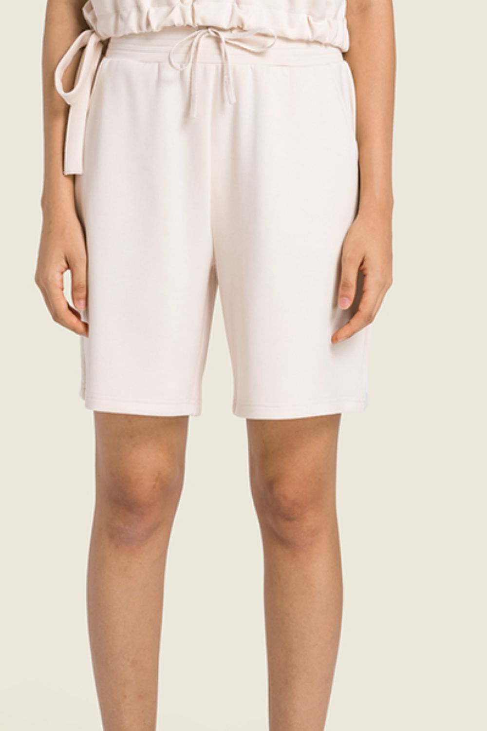 A pair of Drawstring Elastic Waist Sports Bermuda Shorts in solid color, showcasing the elastic waistband and soft fabric.