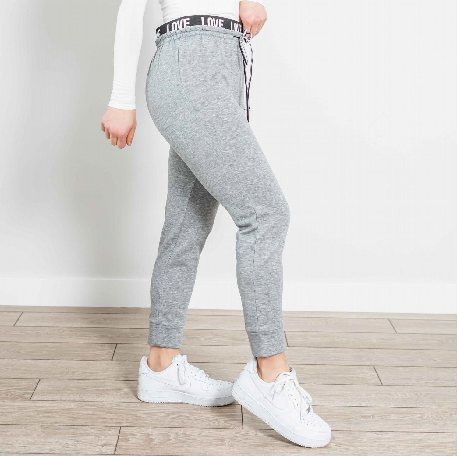 A pair of stylish Drawstring Joggers featuring a Love embellished waistband, showcasing a soft fabric and flattering fit.