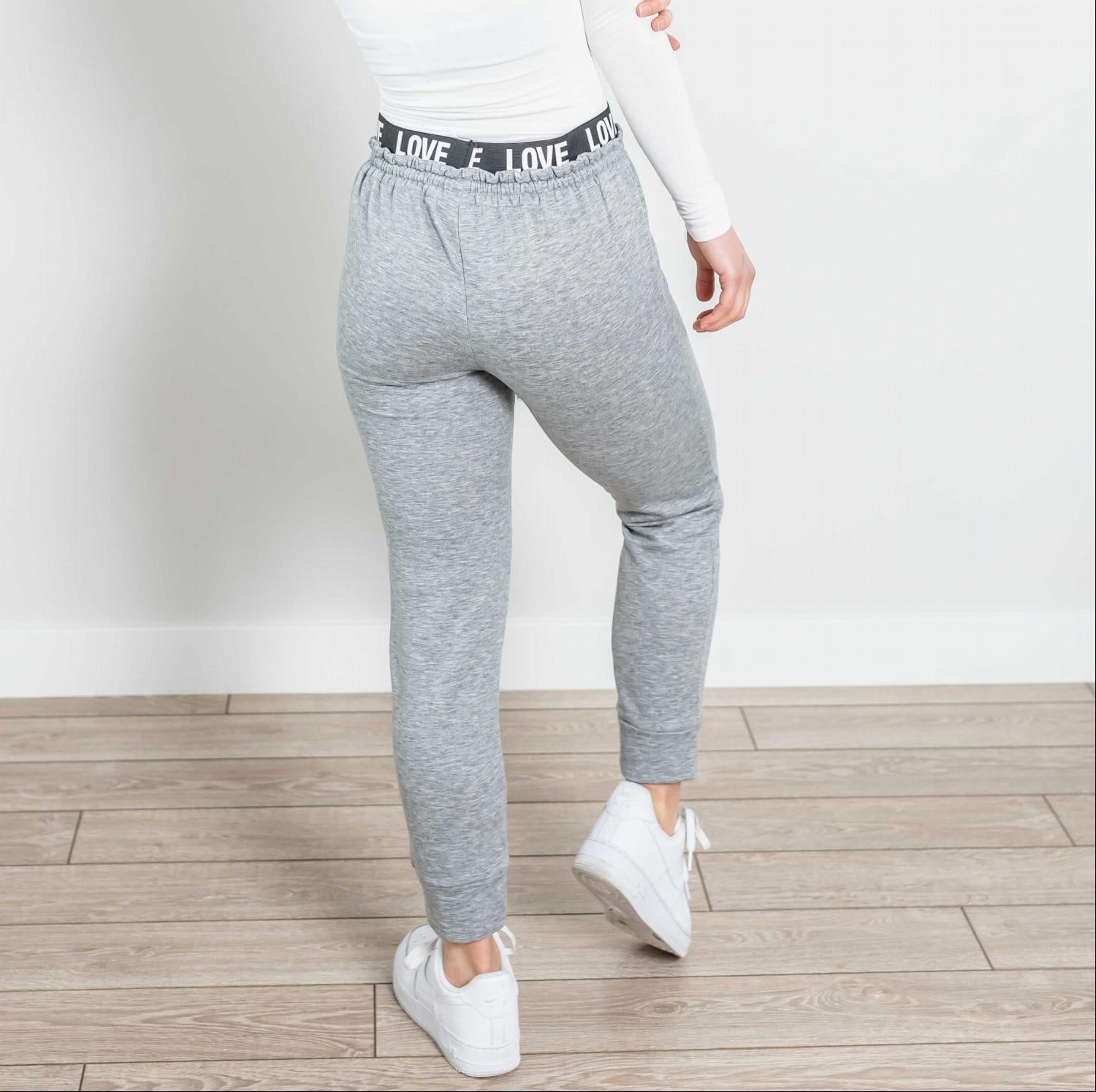 A pair of stylish Drawstring Joggers featuring a Love embellished waistband, showcasing a soft fabric and flattering fit.