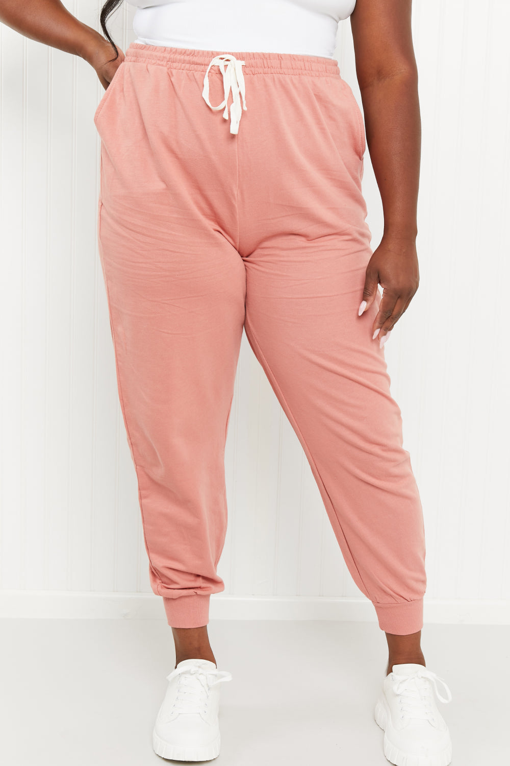 A pair of stylish ash rose drawstring waist joggers with pockets, showcasing their comfortable design and chic color.