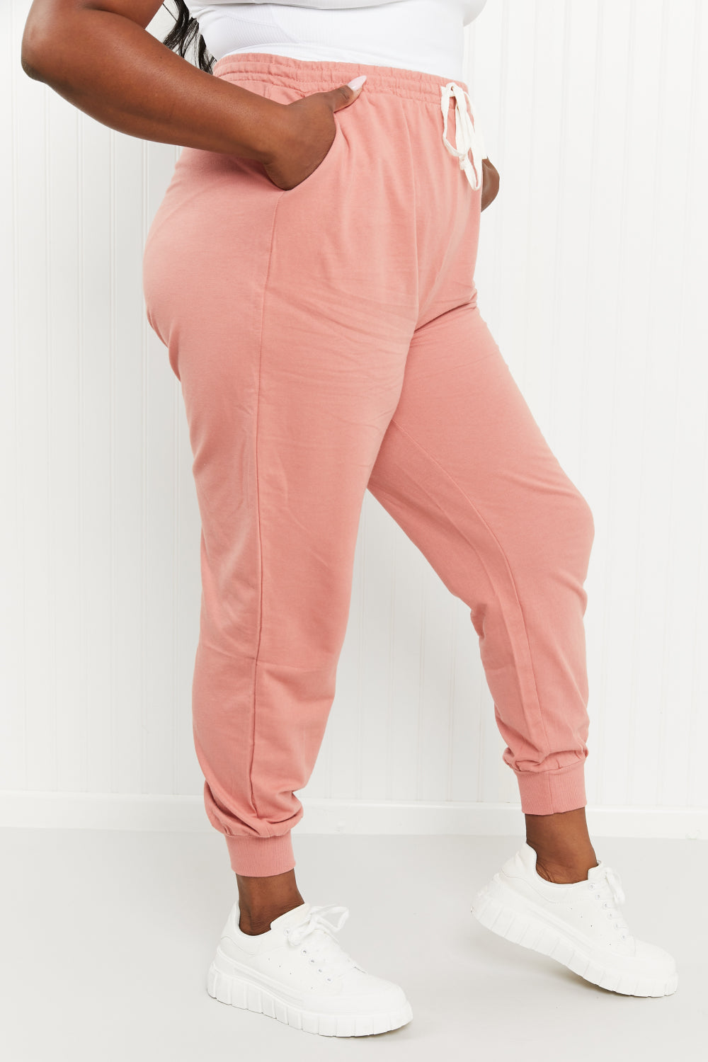 A pair of stylish ash rose drawstring waist joggers with pockets, showcasing their comfortable design and chic color.