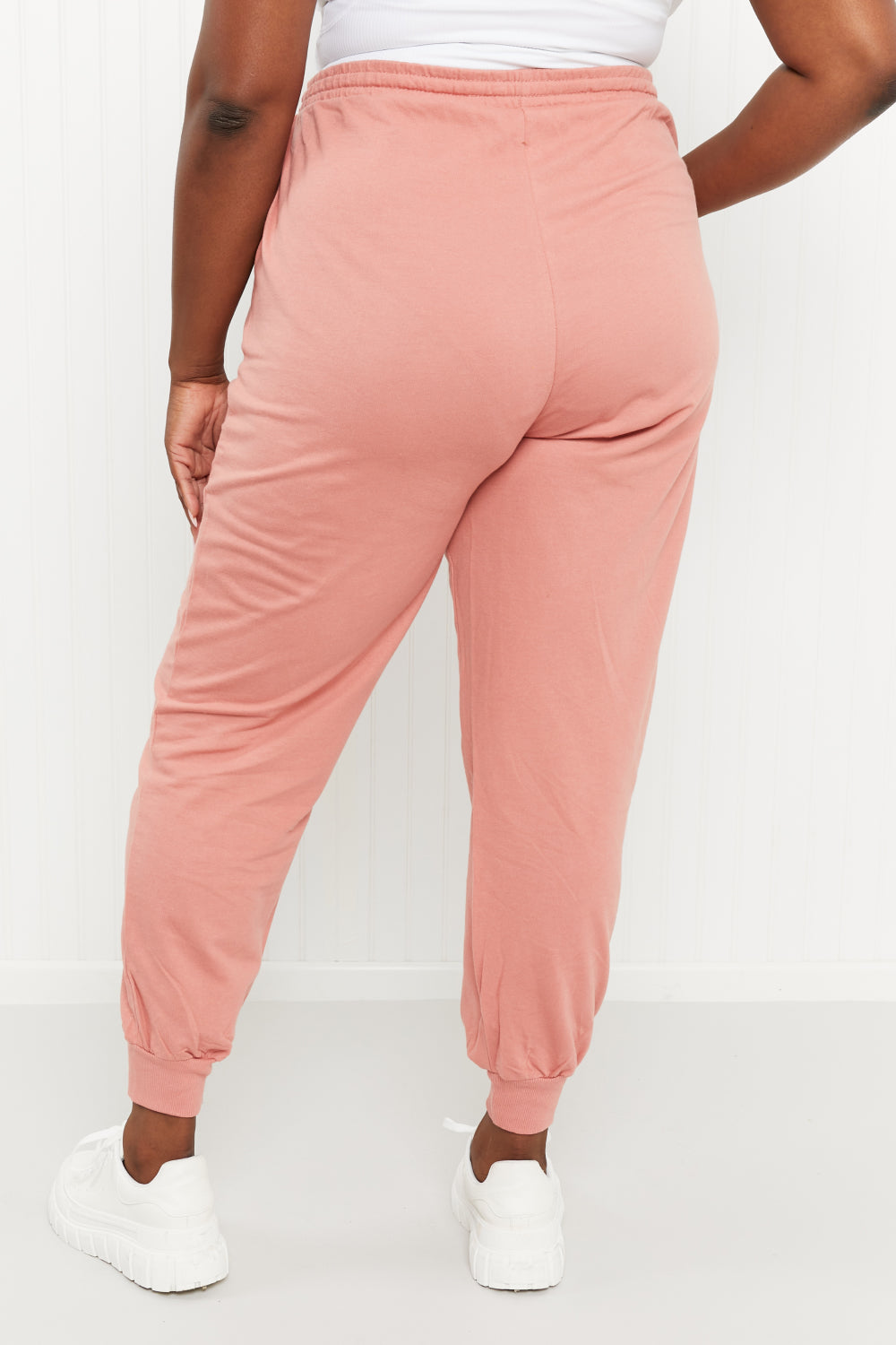 A pair of stylish ash rose drawstring waist joggers with pockets, showcasing their comfortable design and chic color.