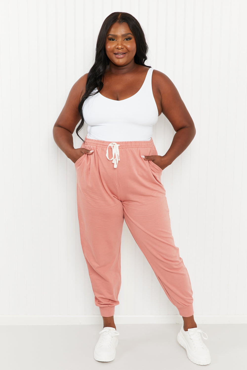 A pair of stylish ash rose drawstring waist joggers with pockets, showcasing their comfortable design and chic color.