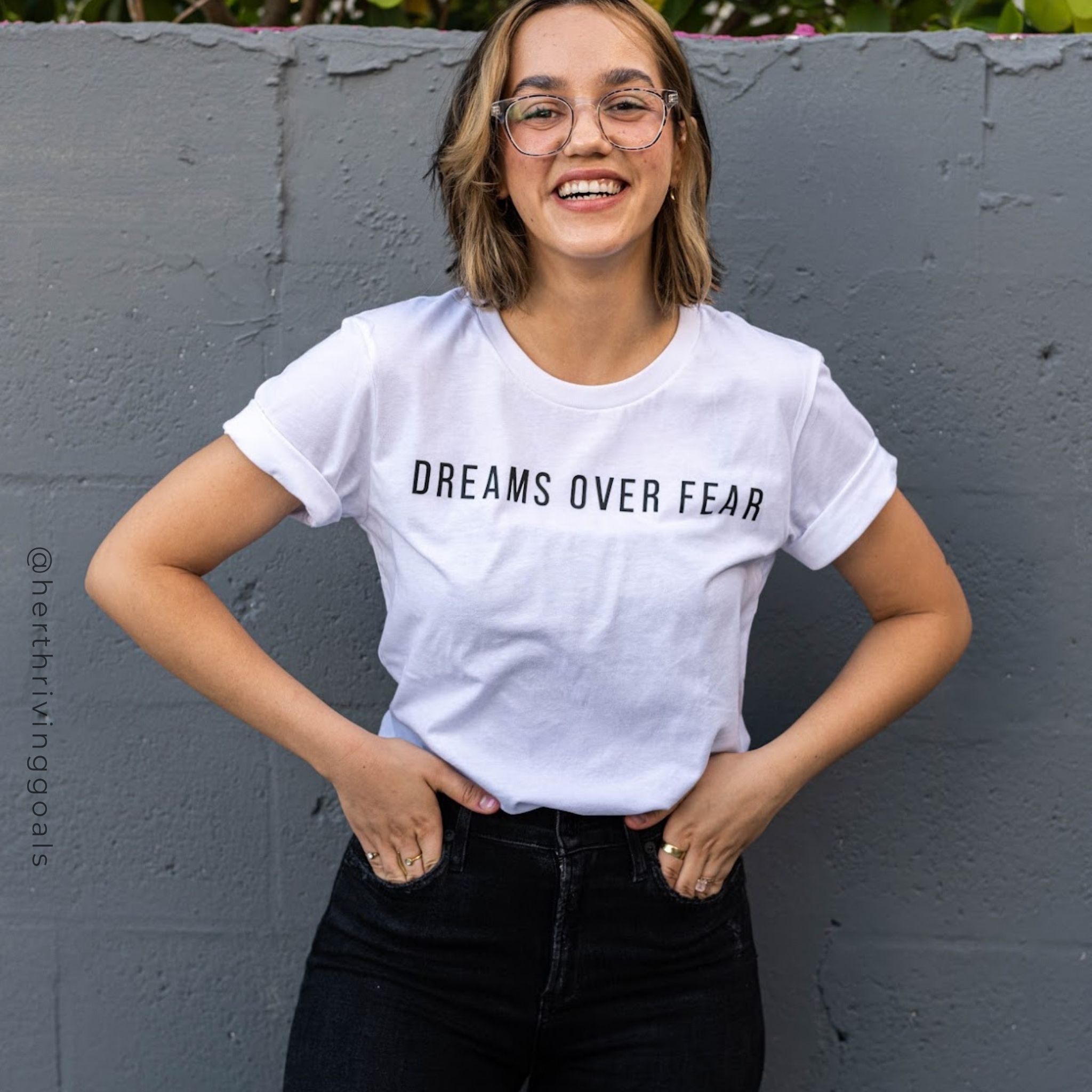 A woman wearing the Dreams Over Fear Tee, showcasing its inspirational message and comfortable fit.