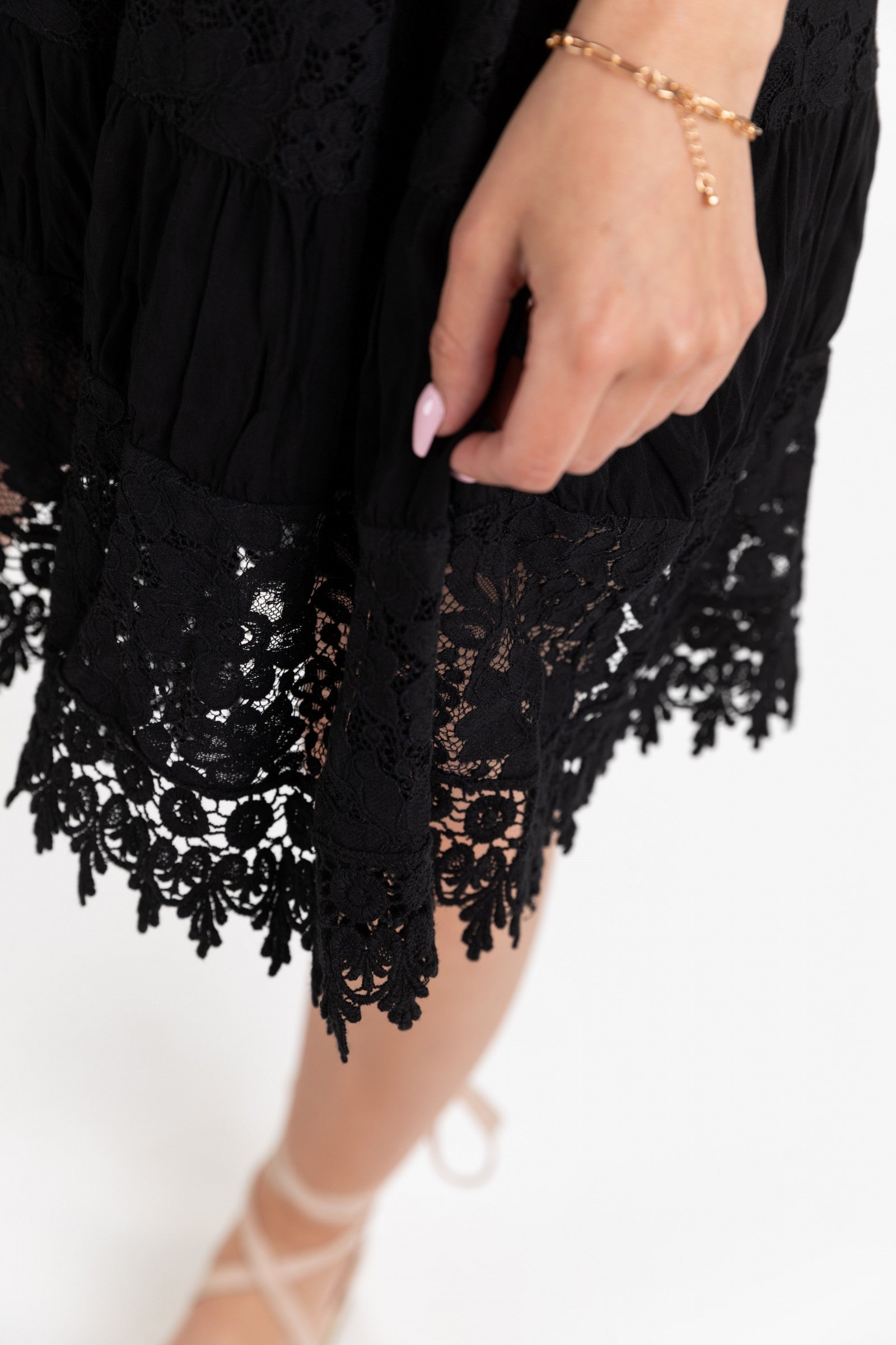 A sophisticated black lace dress featuring an open shoulder design, round collar, and beautiful edges, perfect for elegant occasions.