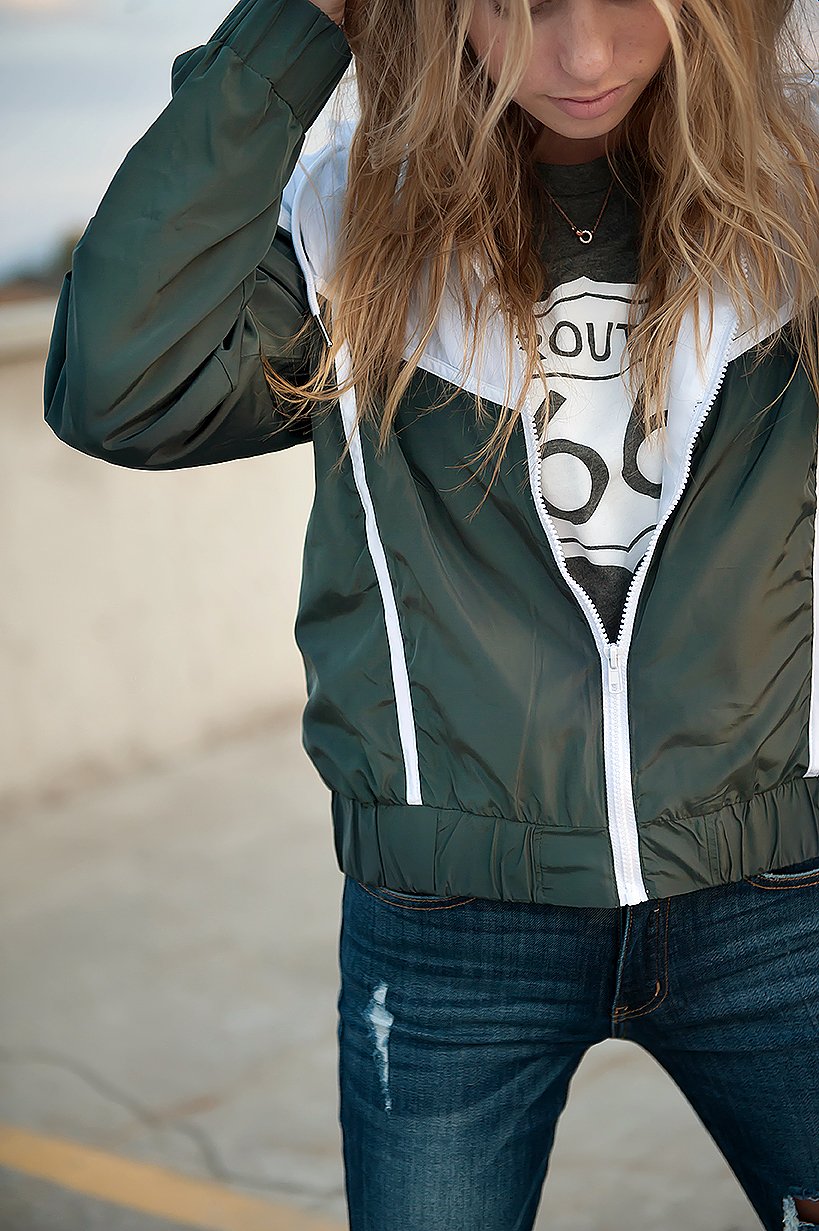 DT Green & White drawstring windbreaker jacket featuring a stylish retro design with white accents and zip closure pockets.