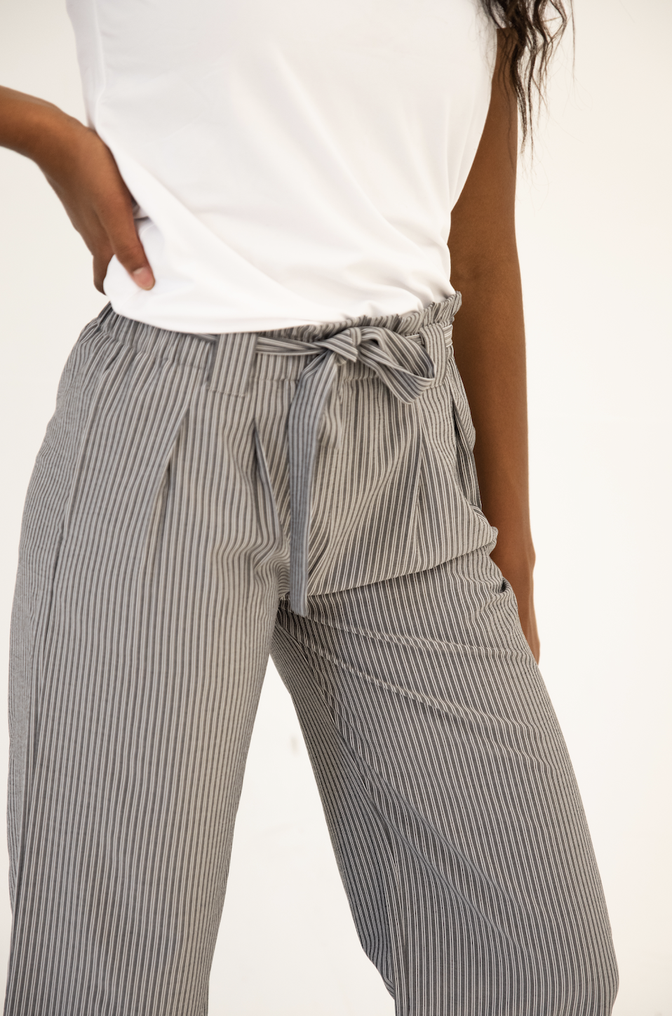 DT Izzy Belted Striped Palazzo Pants in grey and white, showcasing a stylish design with a belt and wide legs.