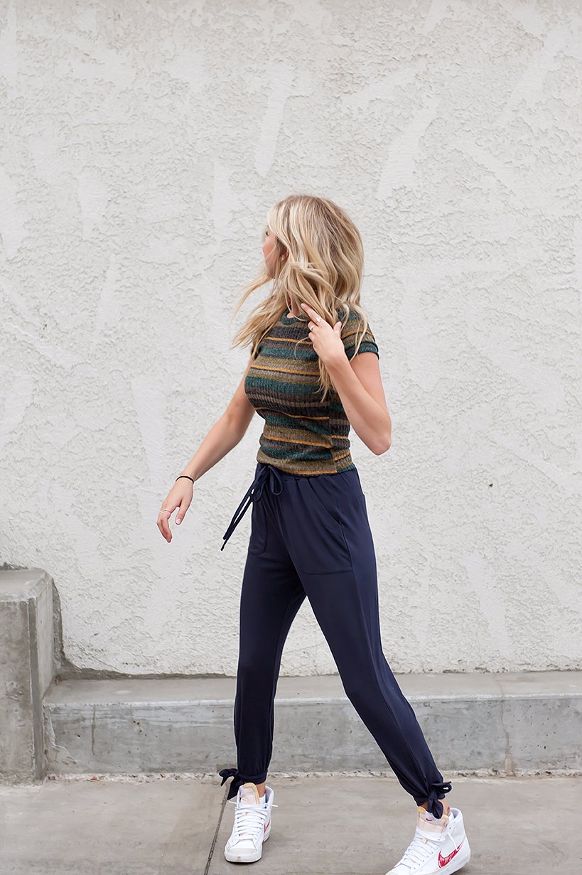 DT Shelby Tie-ankle pants in Navy featuring a feminine knot at the ankle, adjustable drawstring waistband, and functional pockets.