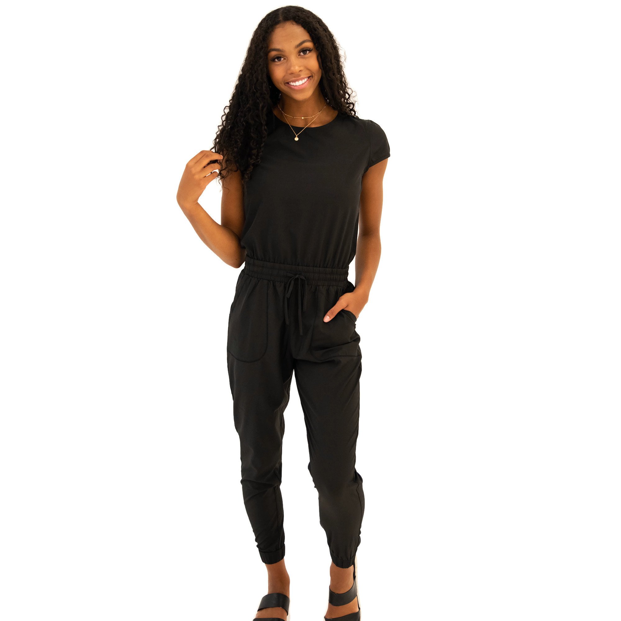 DT UNITY Jumpsuit in Black featuring cap sleeves, side pockets, and an adjustable tie waist, perfect for women and teens.