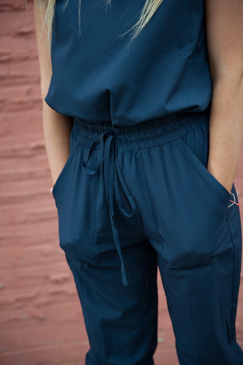 DT Unity Jumpsuit in Navy featuring cap sleeves, elastic waist, and slim cut legs, perfect for women and teens.