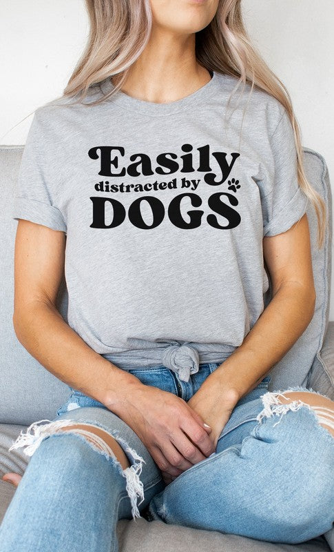 Easily Distracted By Dogs PLUS Graphic Tee featuring a cute paw print design in various colors, made from soft cotton/poly blend fabric.