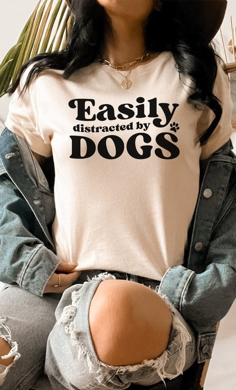 Easily Distracted By Dogs PLUS Graphic Tee featuring a cute paw print design in various colors, made from soft cotton/poly blend fabric.