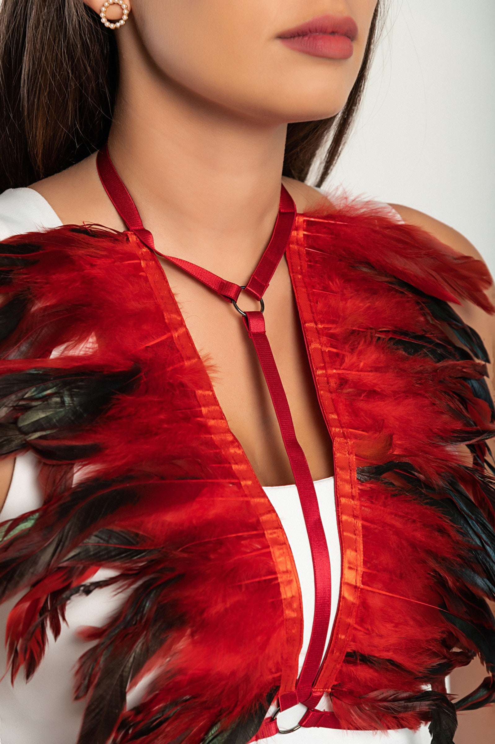 Red elastic strap bra with decorative feathers, featuring adjustable straps and back closure, stylish and comfortable.