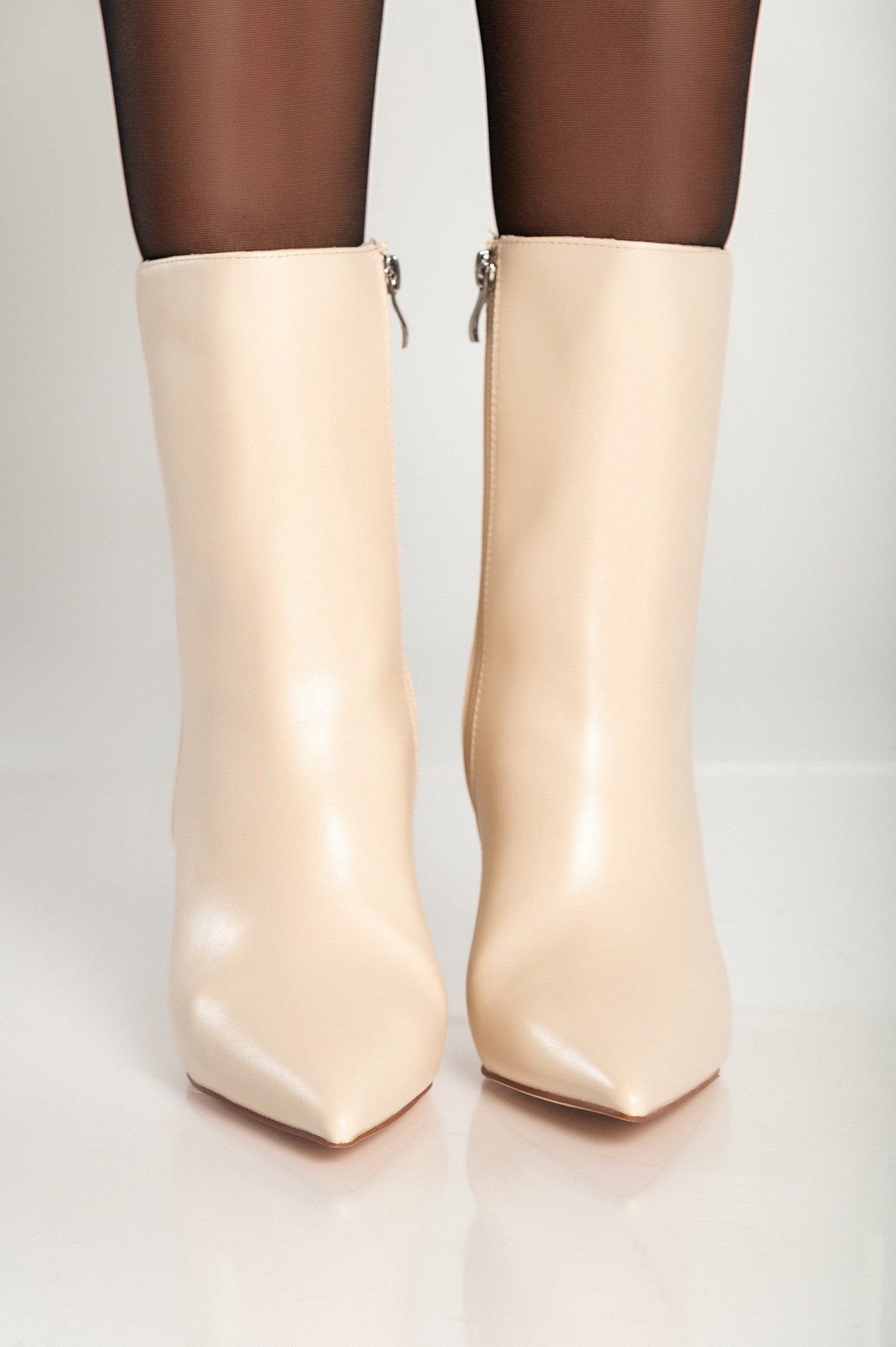 Elegant beige ankle boots with a pointed toe and thin heel, featuring an inside zipper closure for easy wear.