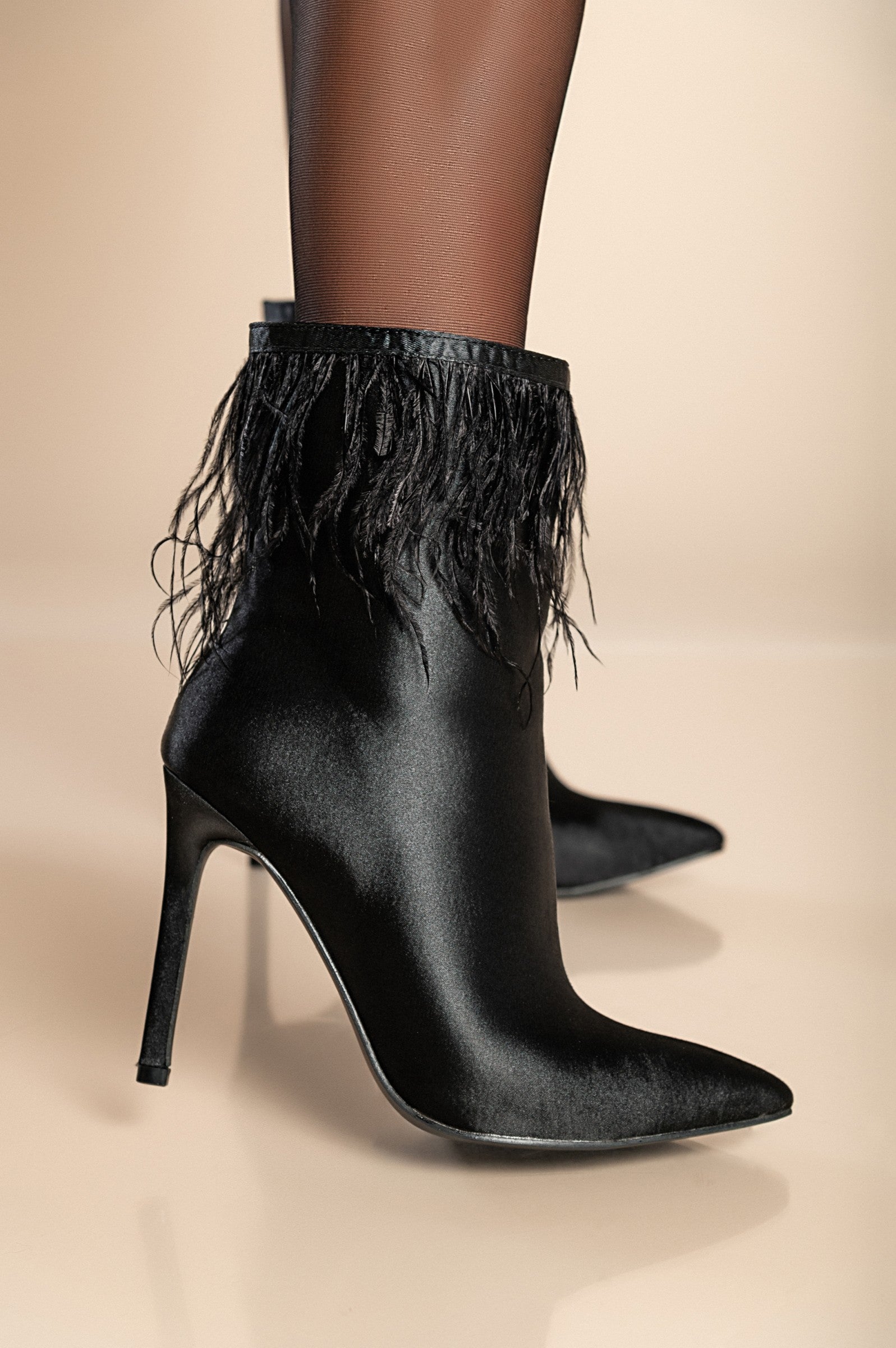 Elegant black ankle boots with high heels, featuring decorative feathers and a pointed toe design.