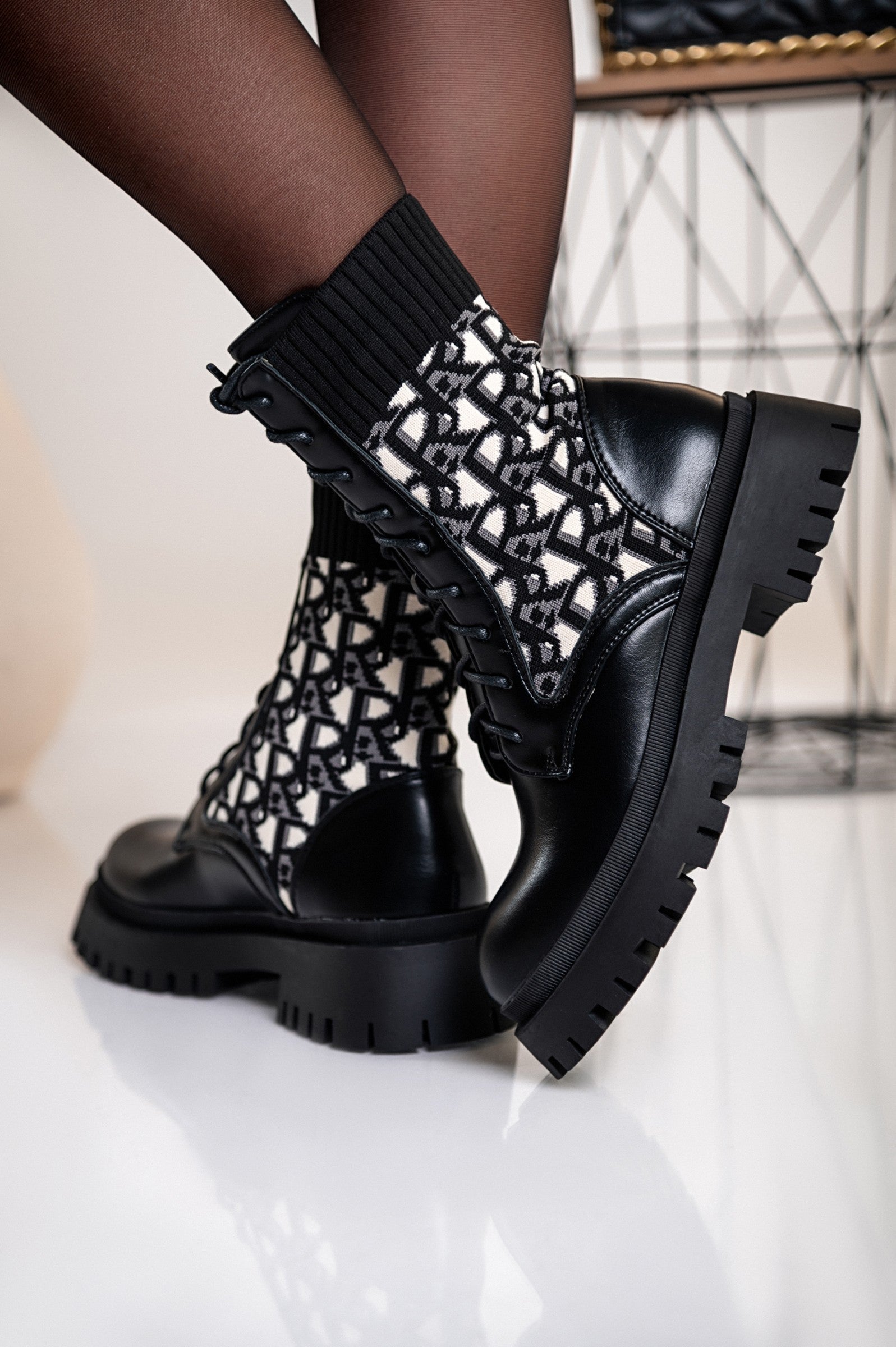 Elegant black ankle boots with print and bows, featuring a round toe and raised sole, made from high-quality artificial leather and textile.